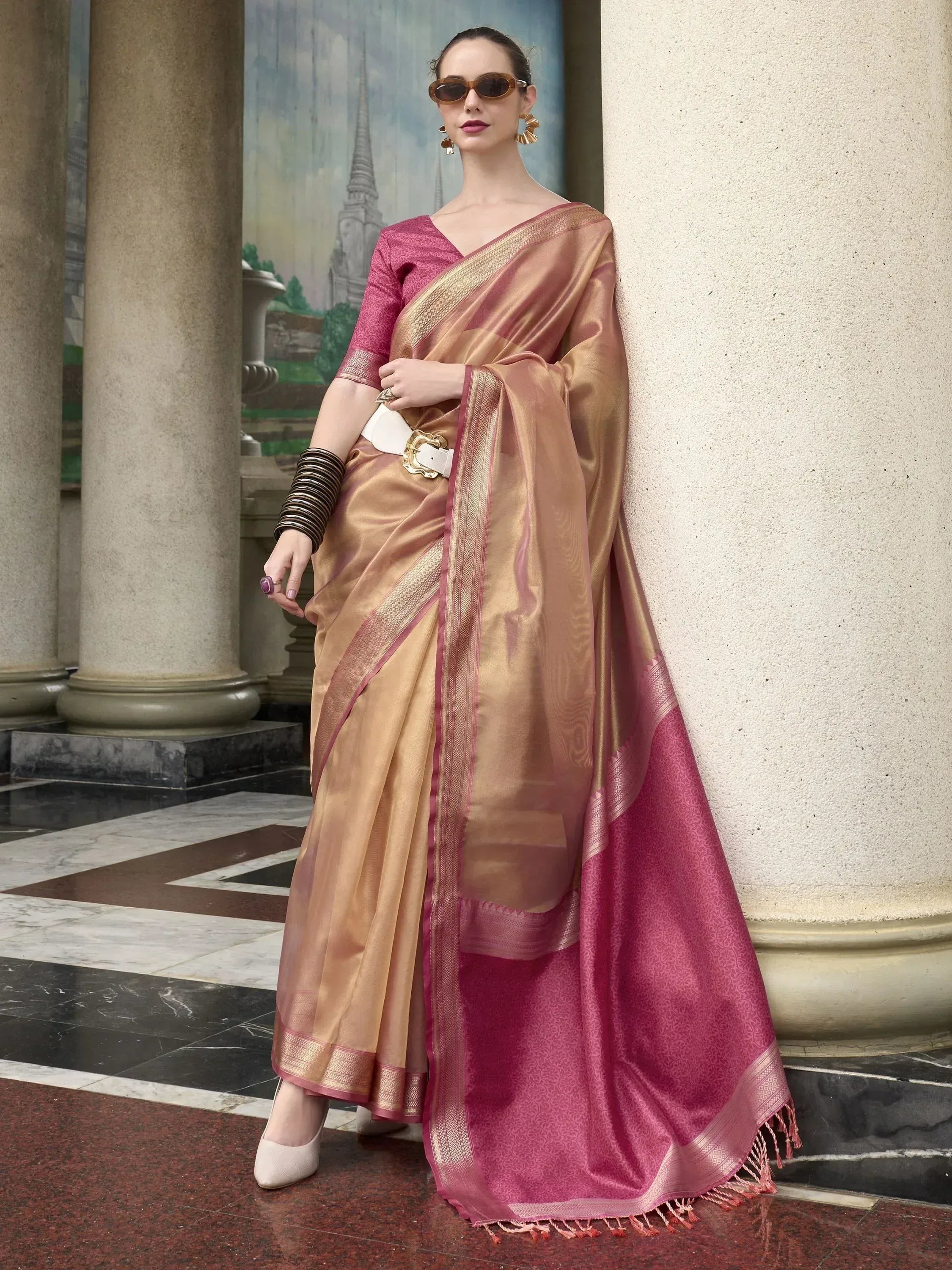 Elegant gold and pink silk saree with intricate border, paired with matching blouse and statement belt for ethnic wear.