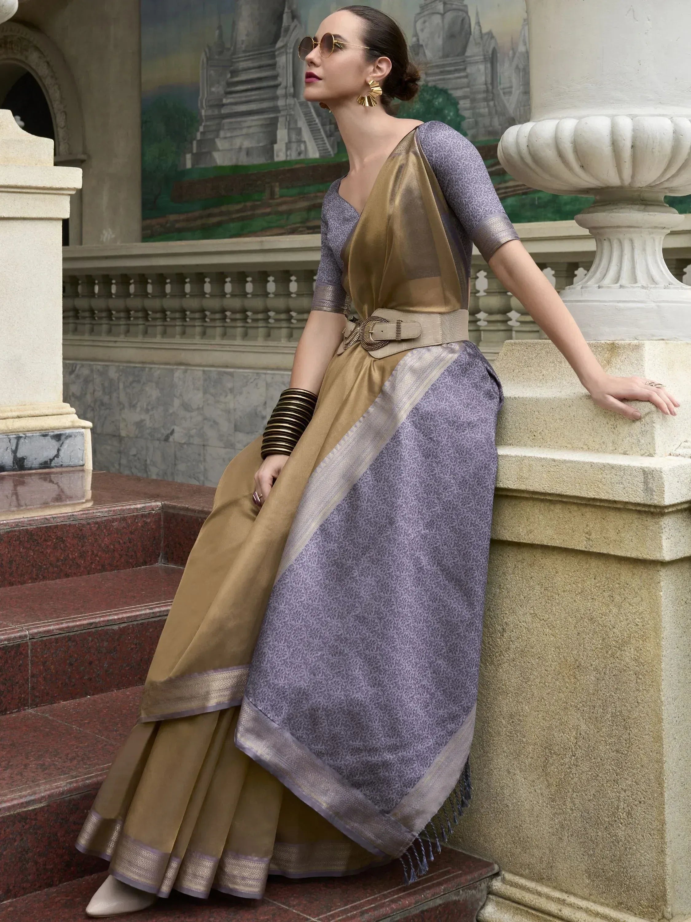 Woman in purple and gold designer saree with belt, styled for ethnic occasions