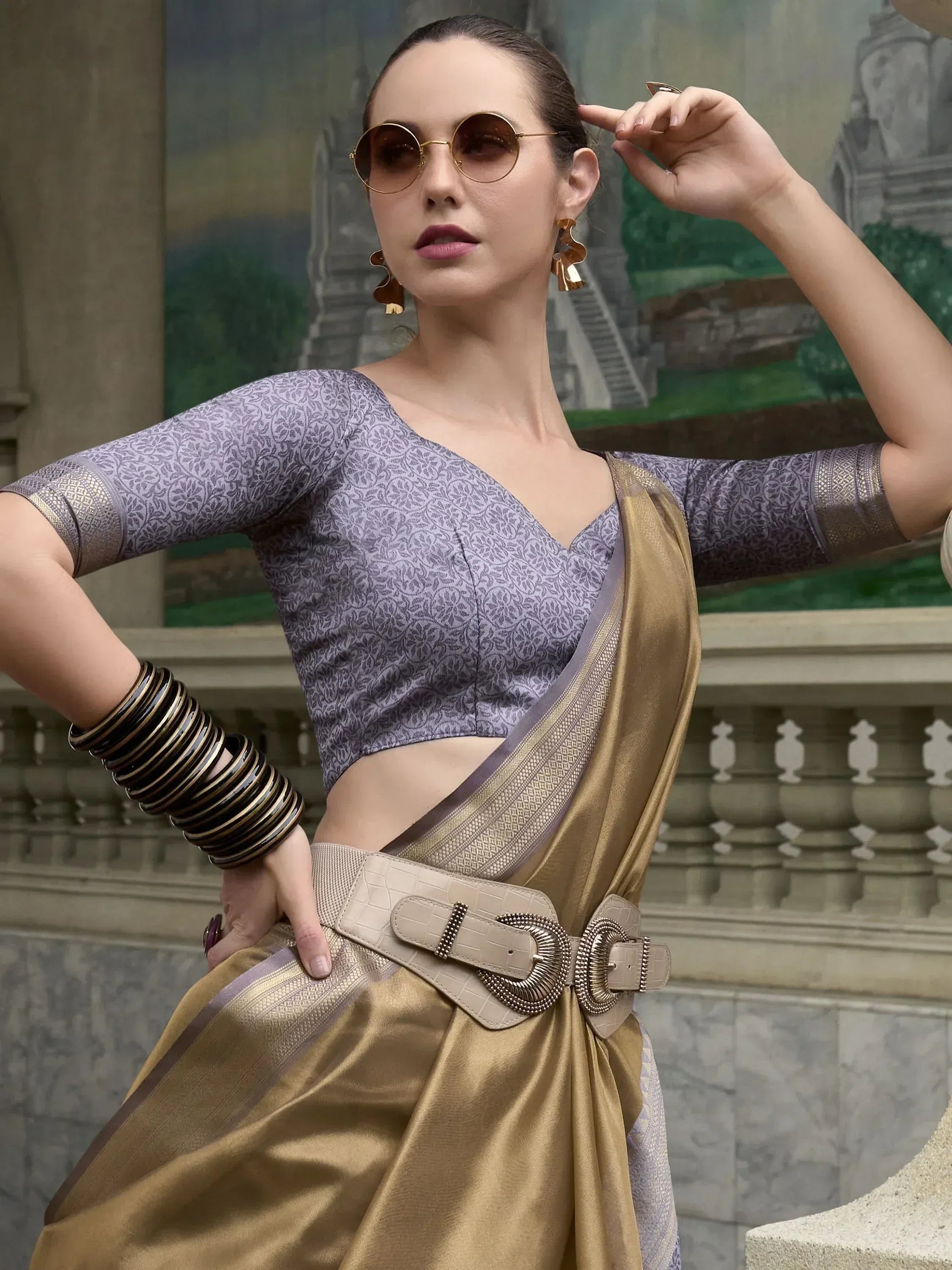 Stylish woman in purple printed blouse and gold saree with belt, modern ethnic wear