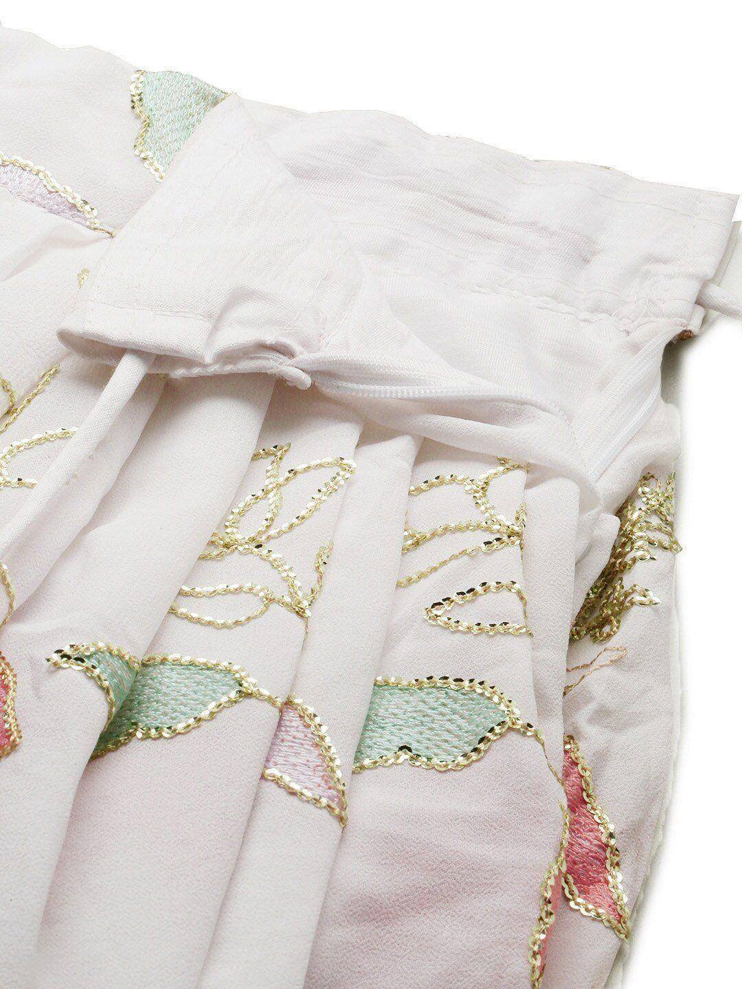 White ethnic skirt with gold thread embroidery and pastel appliqué details, perfect for festive wear