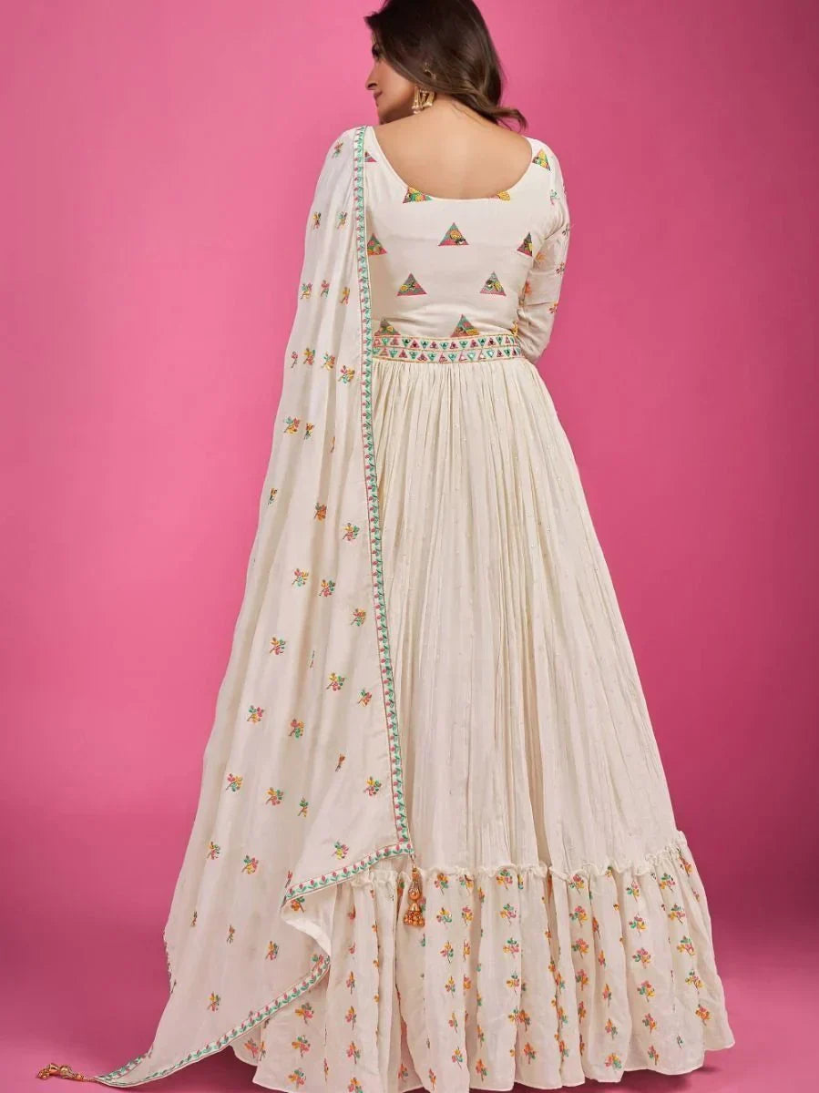 Woman wearing cream embroidered anarkali dress with dupatta, pink background