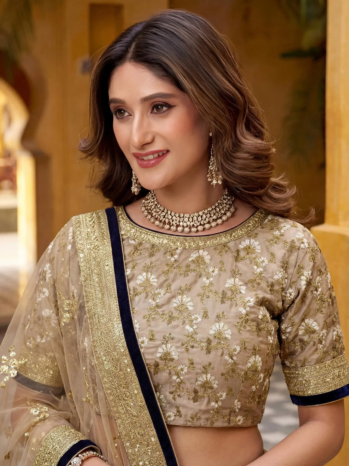 Elegant beige floral embroidered lehenga choli with gold detailing and navy trim