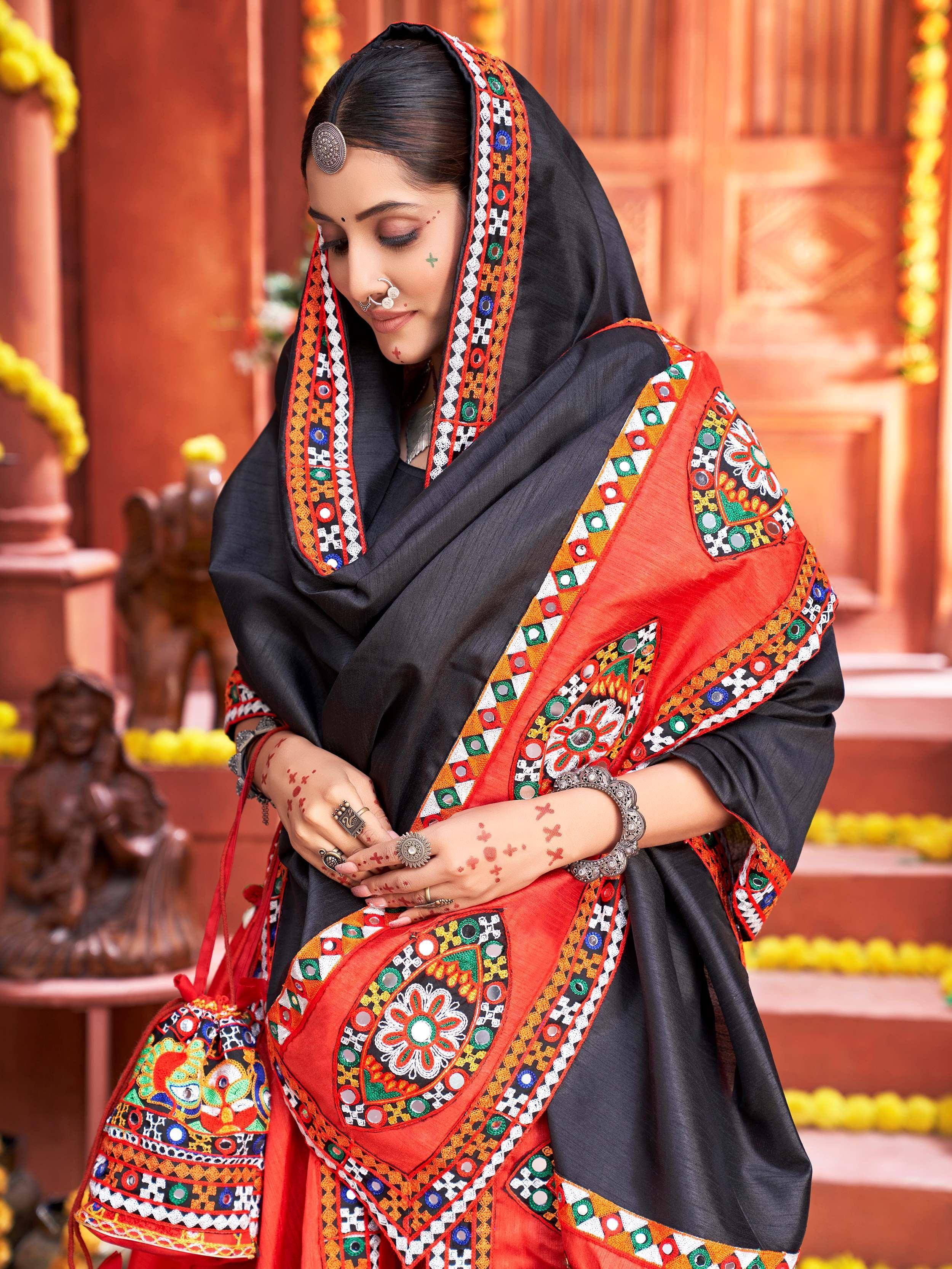Woman in black and red embroidered ethnic wear with mirror work, traditional jewelry, and henna, festive Indian setting