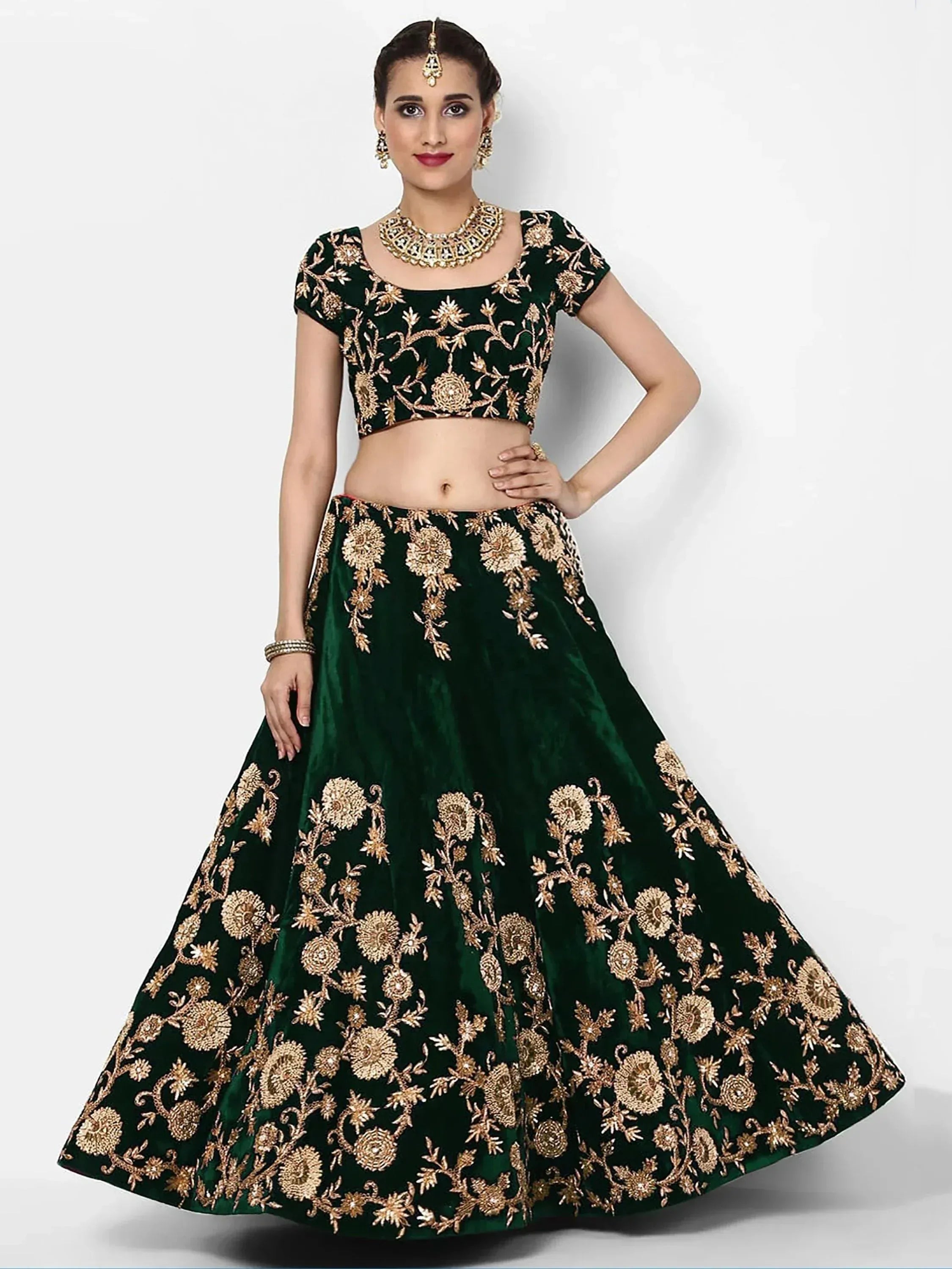 Emerald green velvet lehenga choli with gold floral embroidery, perfect for Indian weddings and festive occasions.