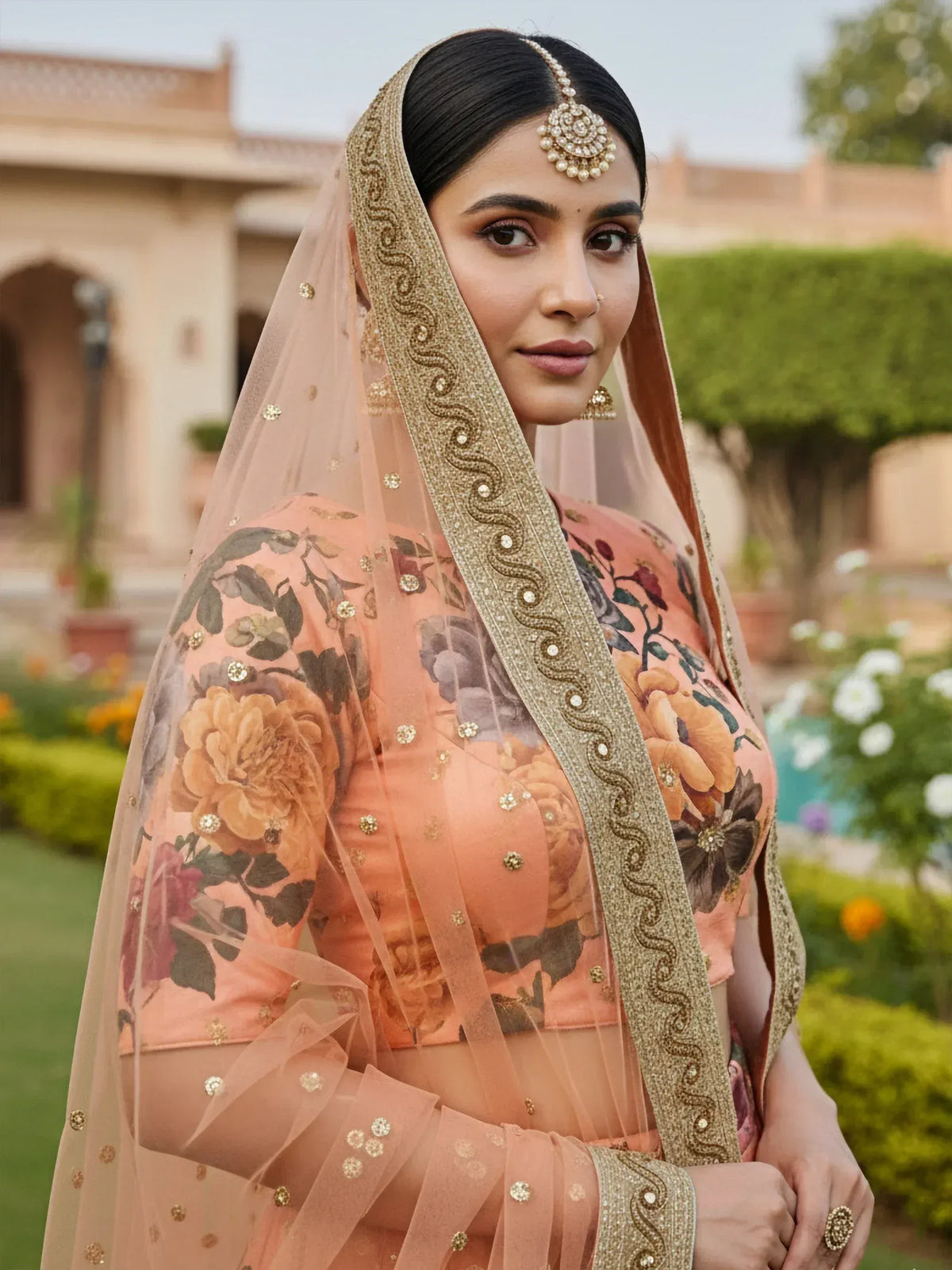 Elegant peach floral lehenga choli with gold embroidery and sheer dupatta, perfect for Indian weddings