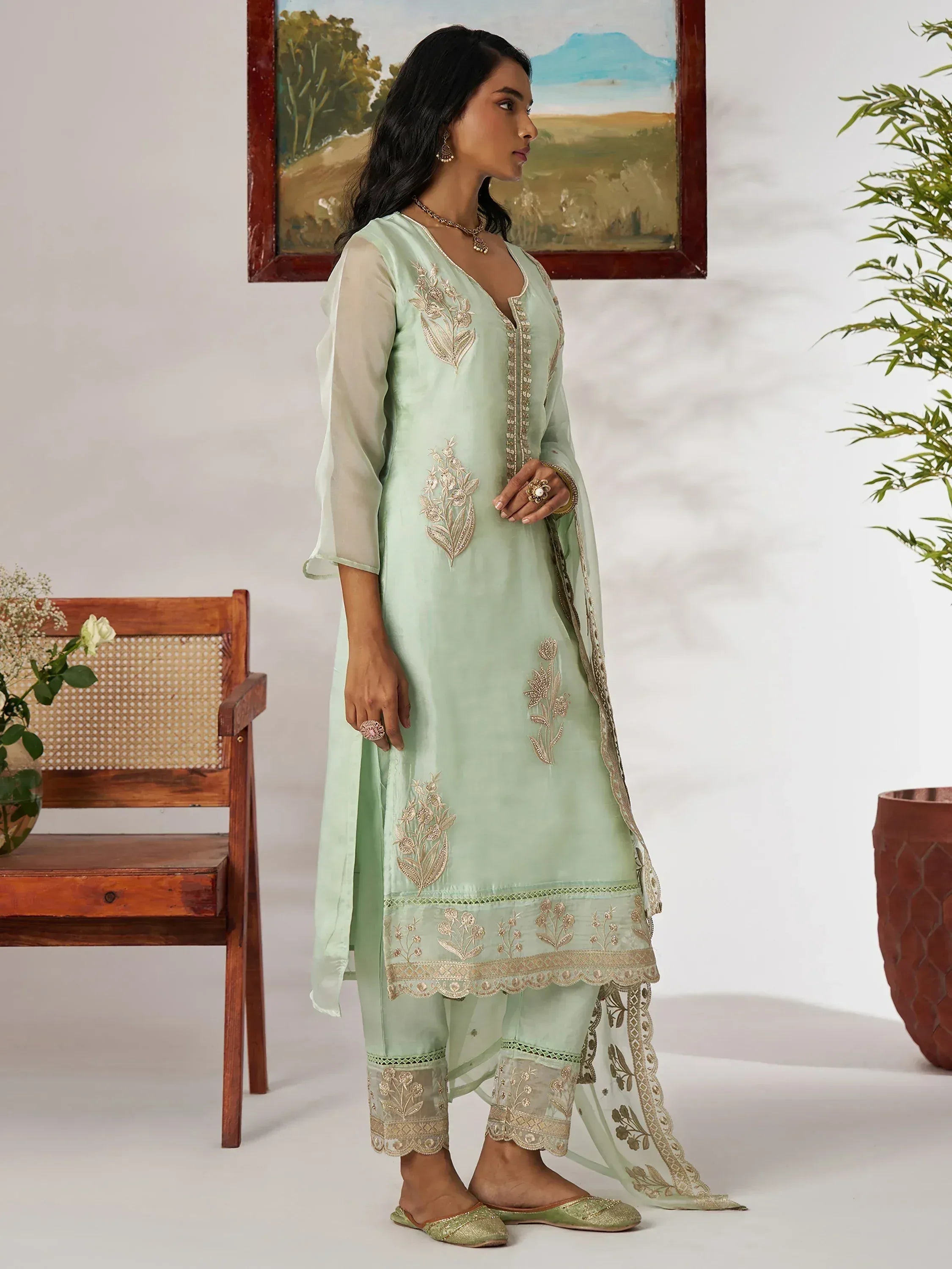 Mint green embroidered salwar kameez with gold floral work, sheer sleeves, and matching dupatta for ethnic wear.