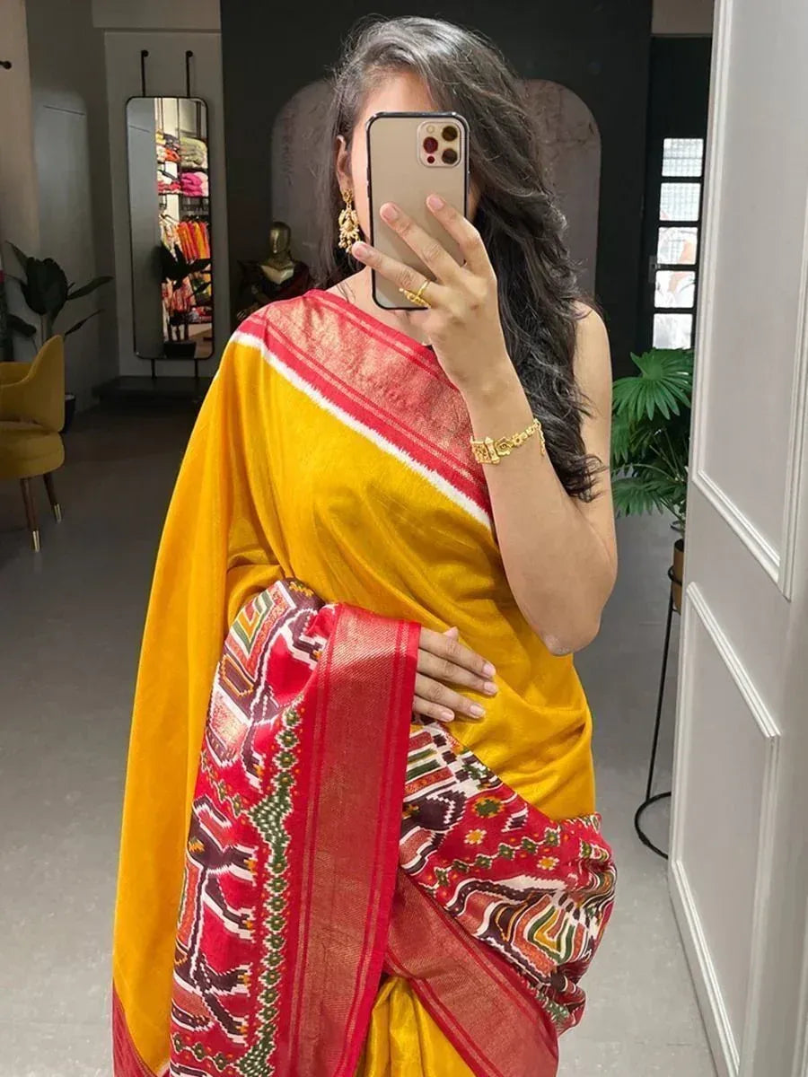 Yellow and red ethnic saree with printed border, worn for traditional occasions