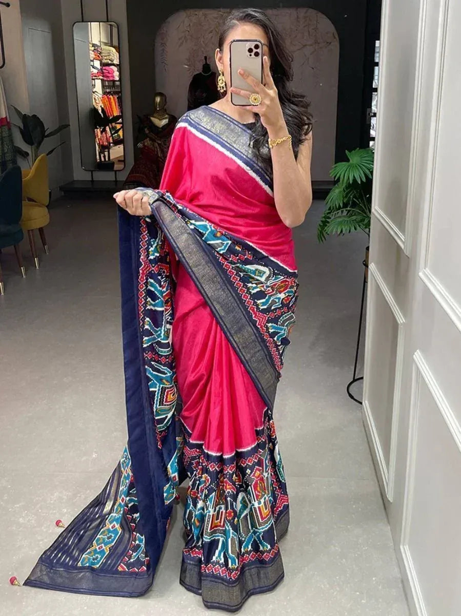 Vibrant pink saree with intricate blue and red border designs, perfect for ethnic occasions.