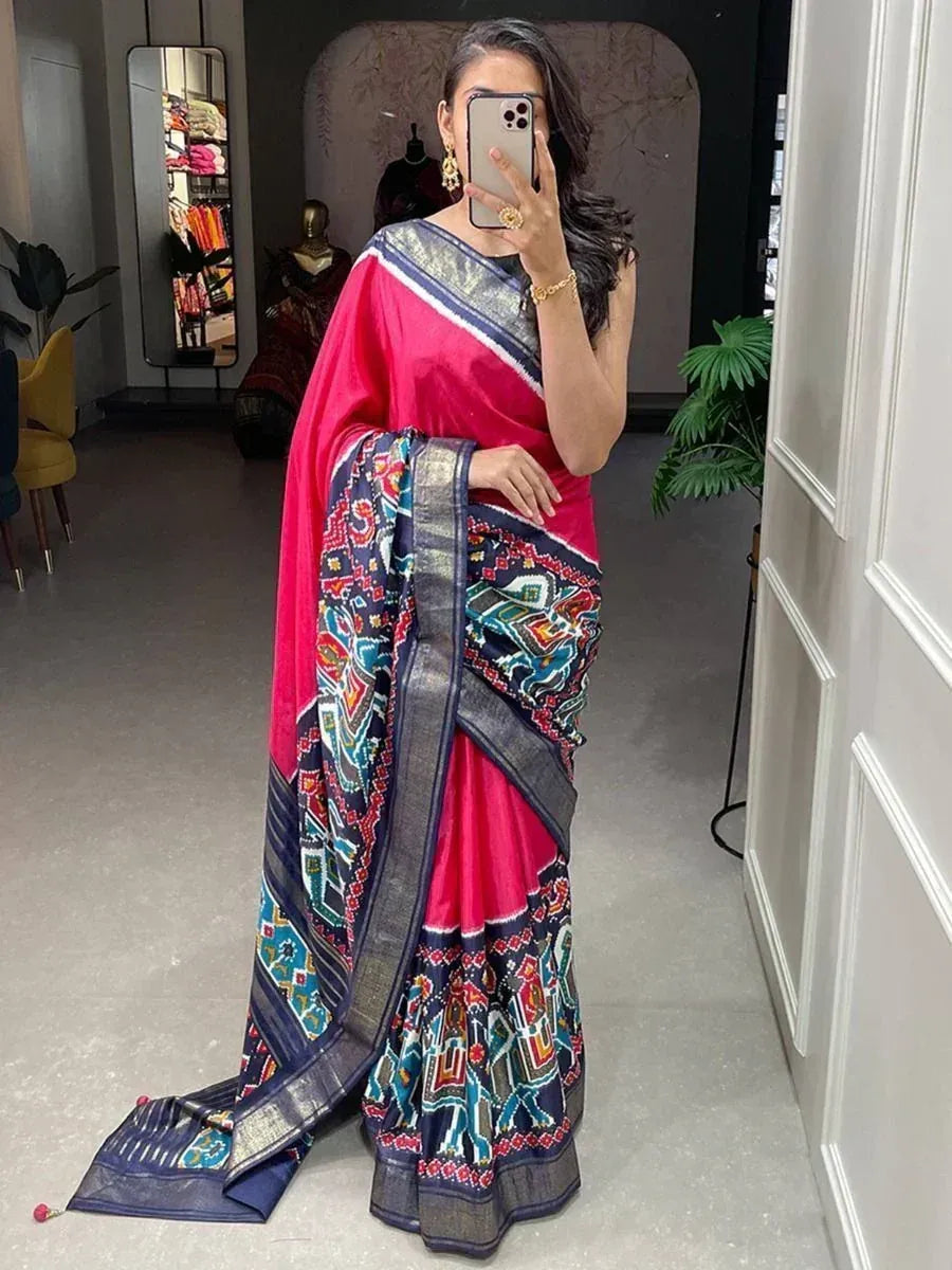 Woman in vibrant pink saree with intricate blue and multicolor border, perfect for ethnic occasions