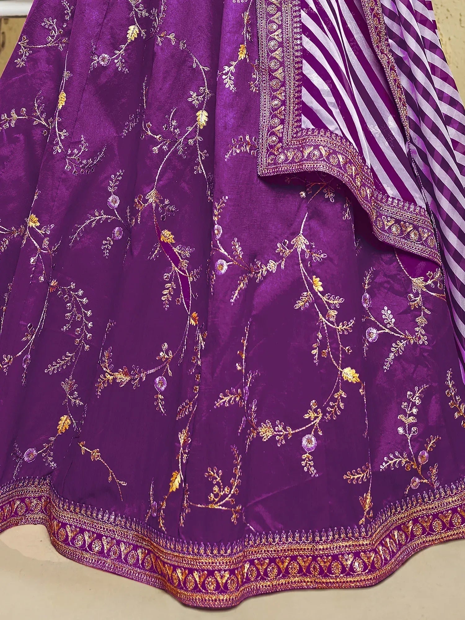Purple embroidered lehenga with golden floral motifs and striped dupatta, ideal for Indian ethnic wear.