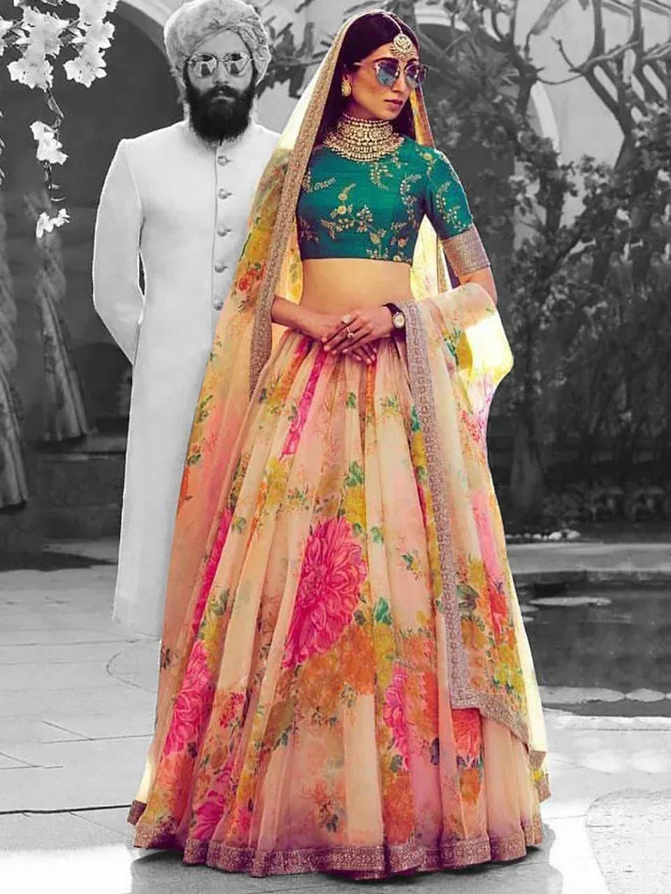 Woman in floral lehenga choli with green blouse, gold jewelry, and dupatta, styled for Indian ethnic wear