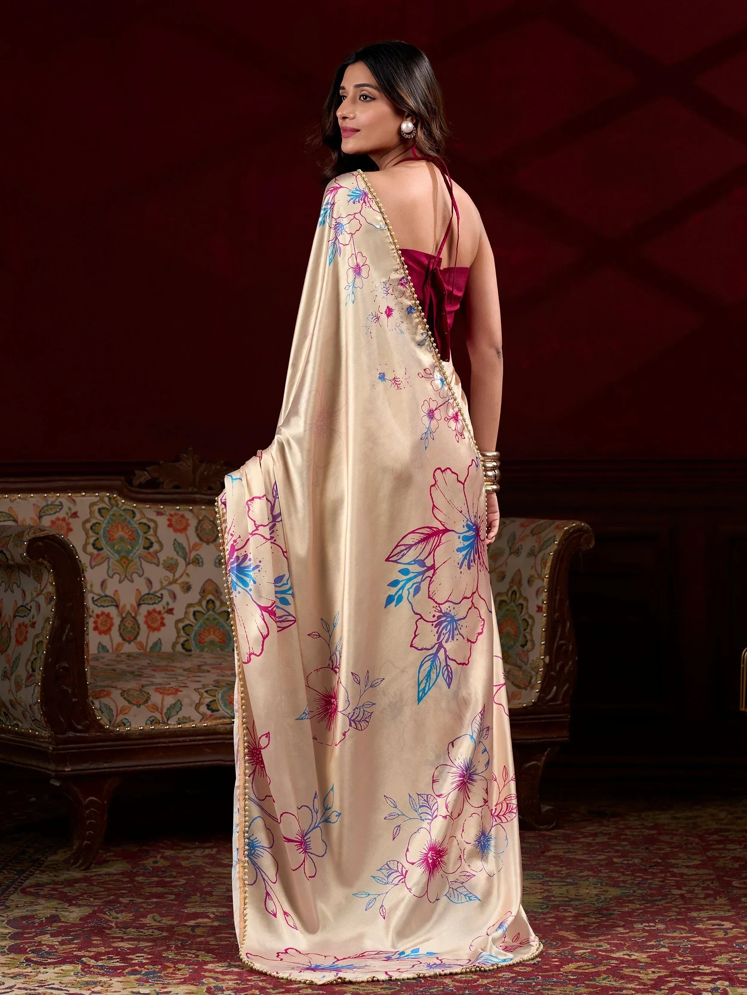 Woman in elegant floral print saree with pearl border, showcasing Indian ethnic wear for festive occasions