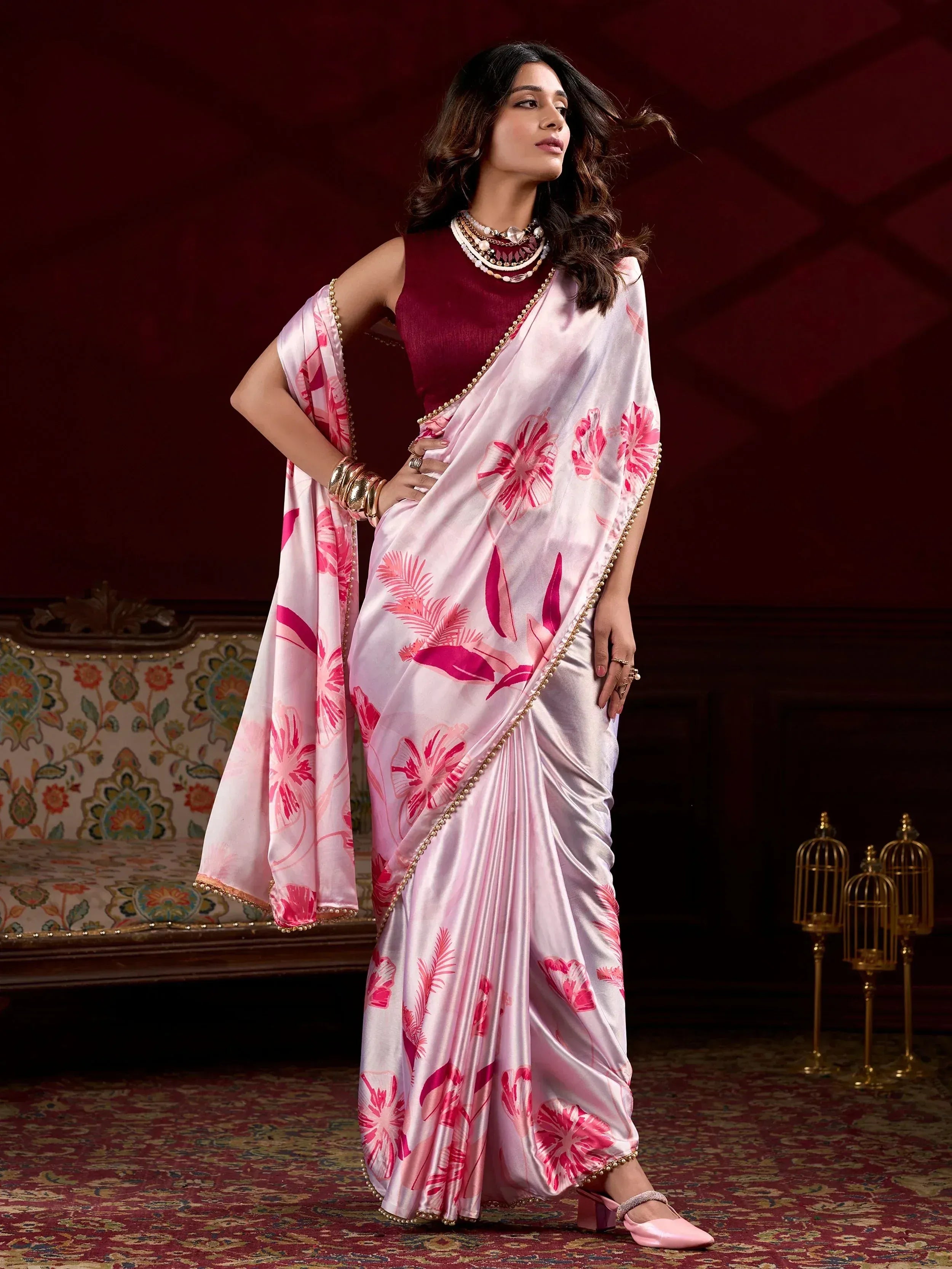 Pink floral print saree with gold border, paired with maroon blouse, perfect for ethnic occasions