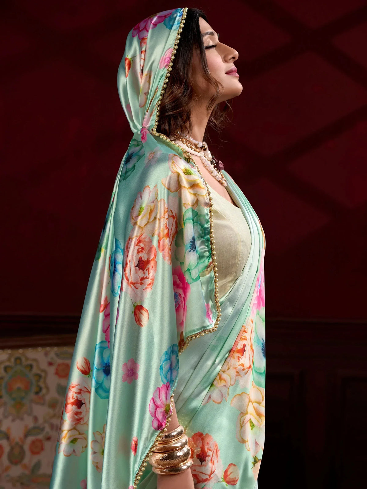 Woman in floral printed mint green saree with pearl border, ethnic Indian wear