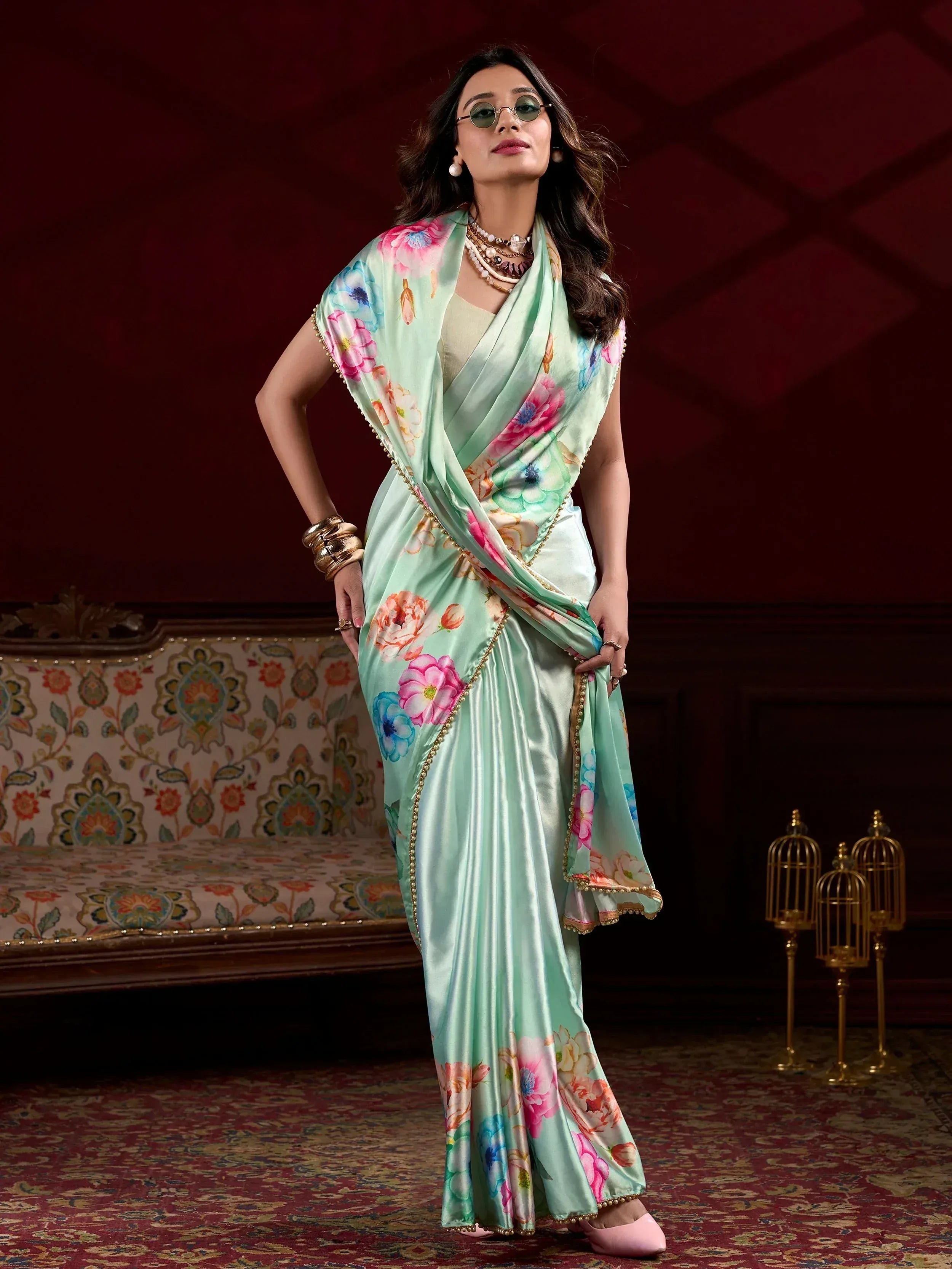 Mint green floral saree with gold trim, styled with sunglasses and layered jewelry for ethnic wear