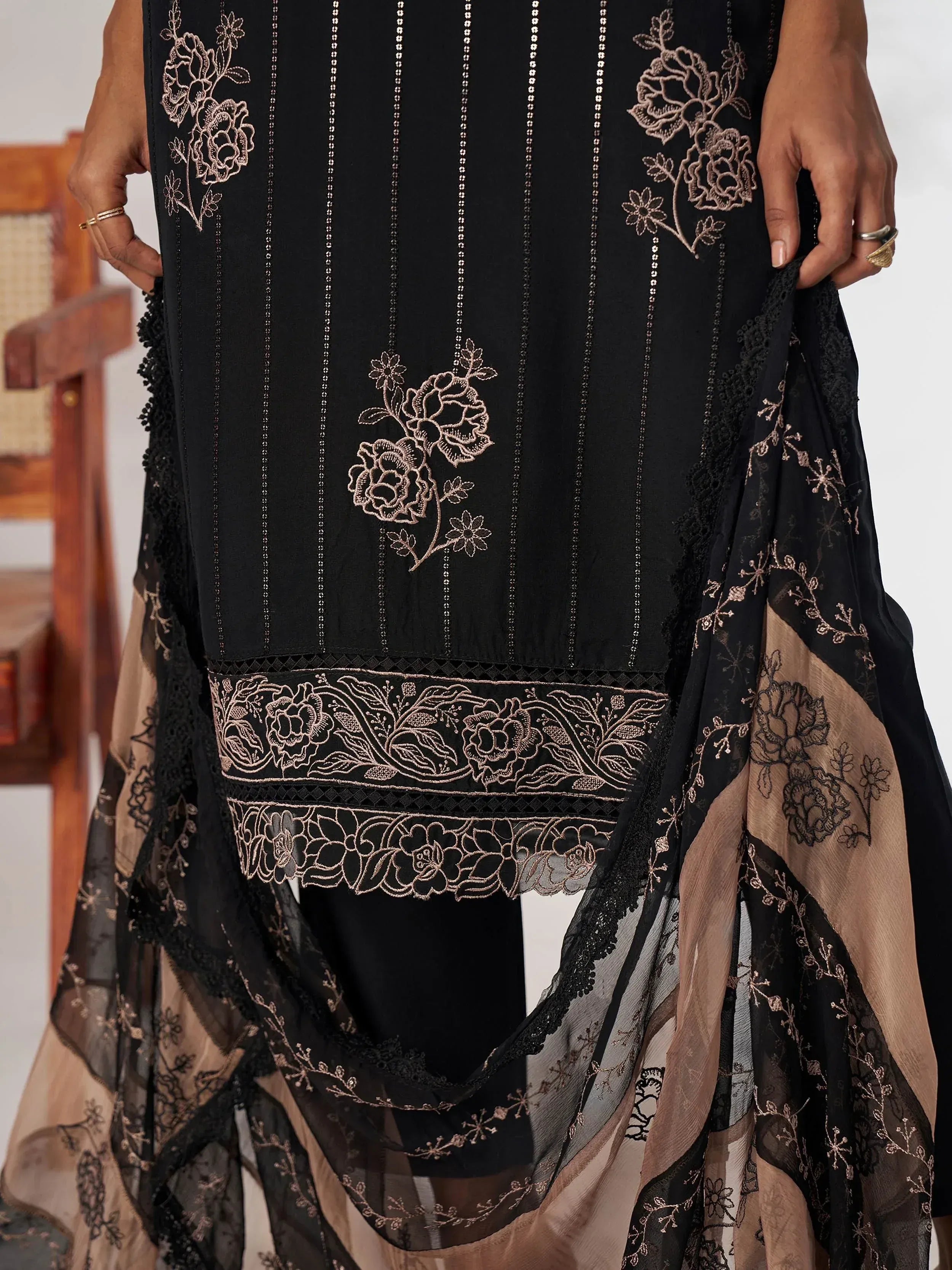 Black ethnic gown with gold floral embroidery and sheer overlay, perfect for Indian occasions
