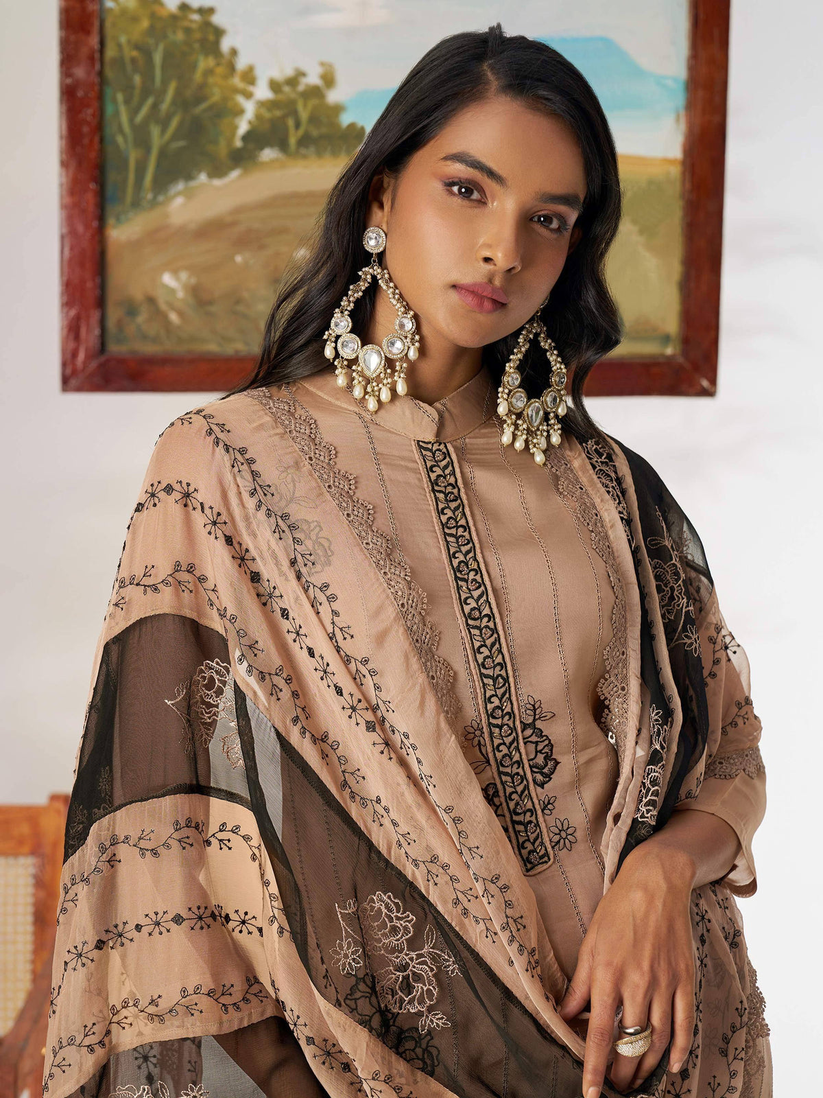 Elegant beige and black embroidered ethnic gown with lace detailing and statement jewelry