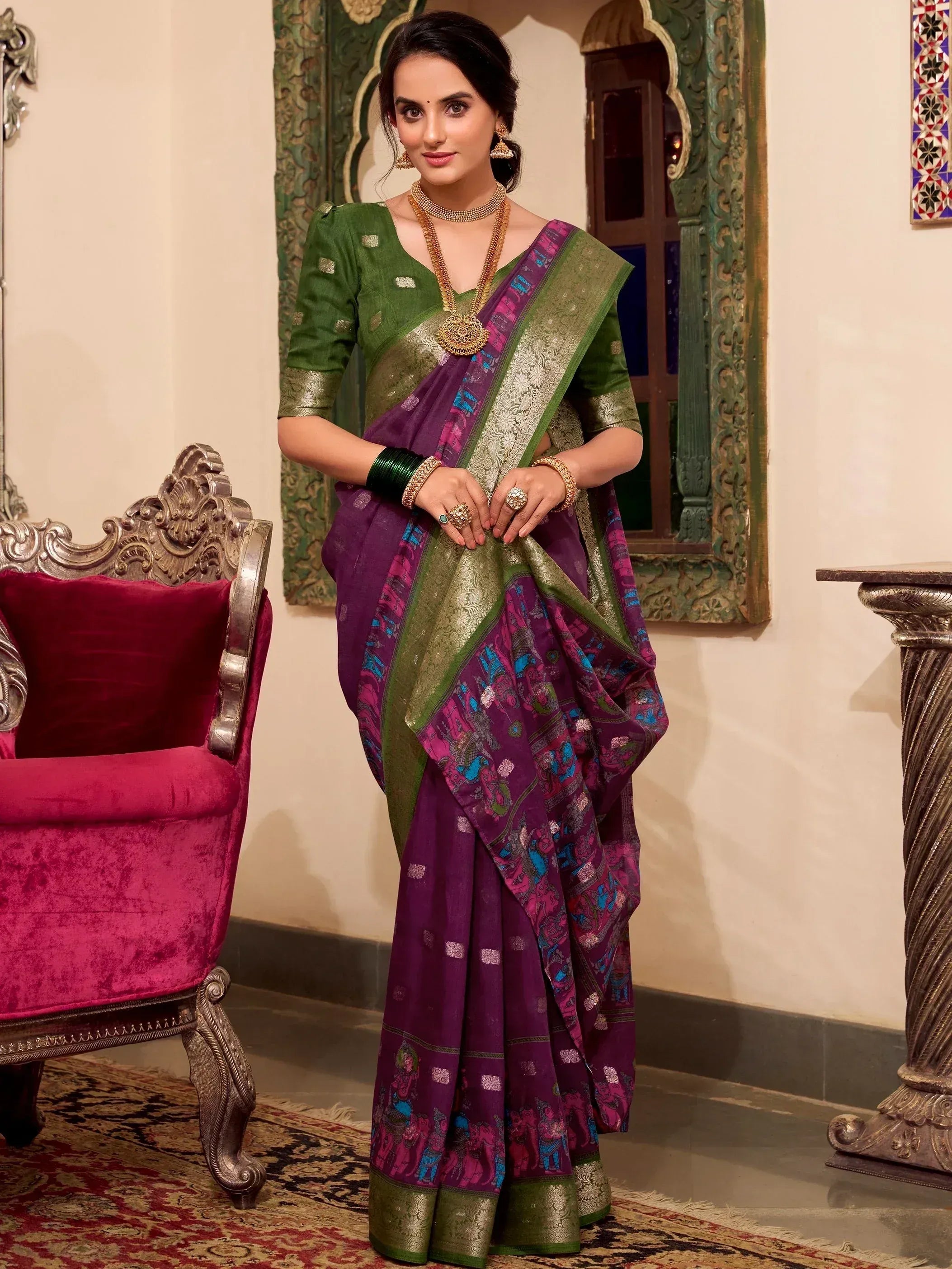 Woman in purple and green printed saree with gold border, traditional Indian ethnic wear