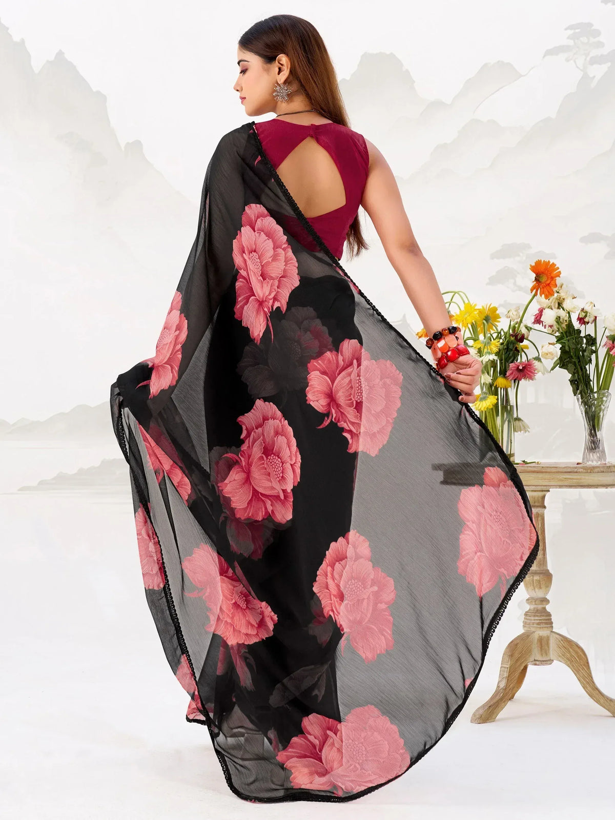 Black saree with pink floral print, paired with maroon blouse, elegant ethnic wear