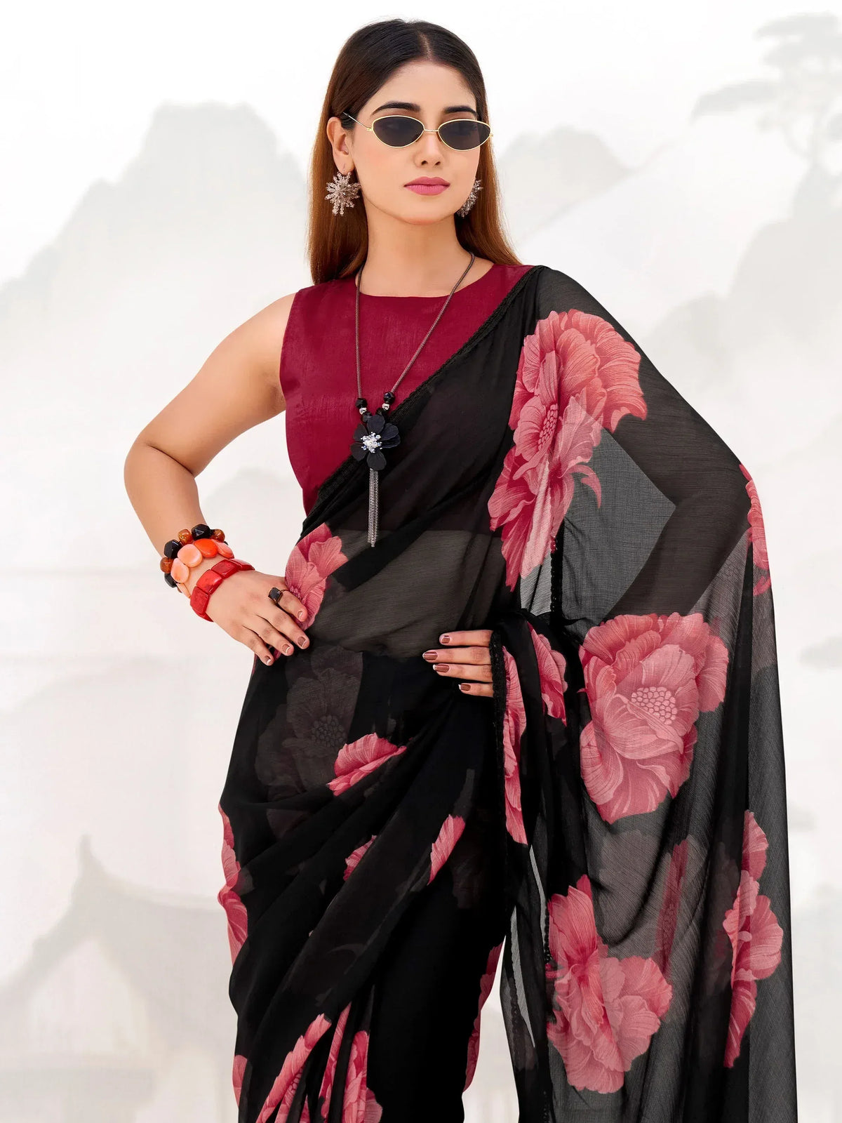 Black saree with pink floral print, paired with maroon blouse and stylish accessories