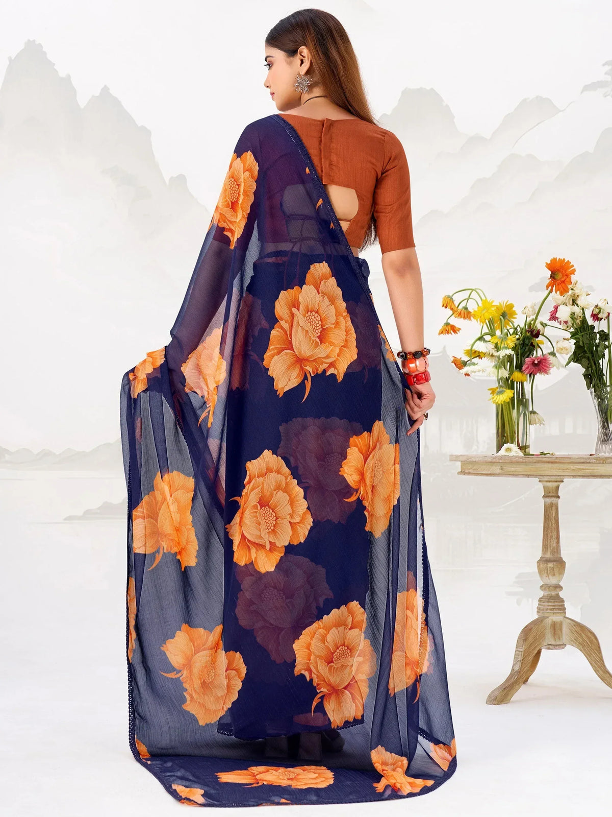 Navy blue saree with orange floral print, paired with a rust blouse, perfect for ethnic occasions.