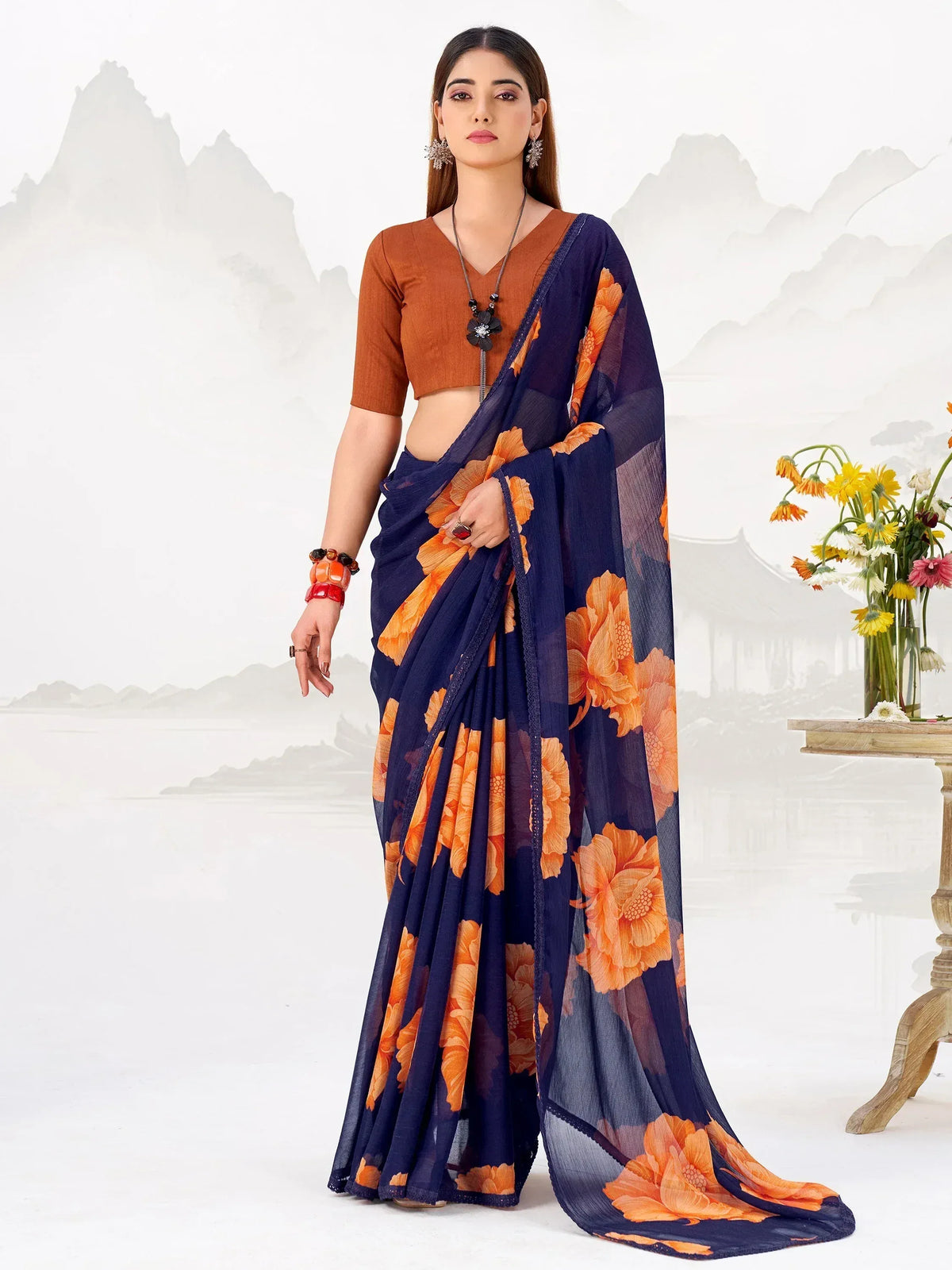 Navy blue saree with orange floral print, paired with brown blouse, perfect for ethnic occasions.