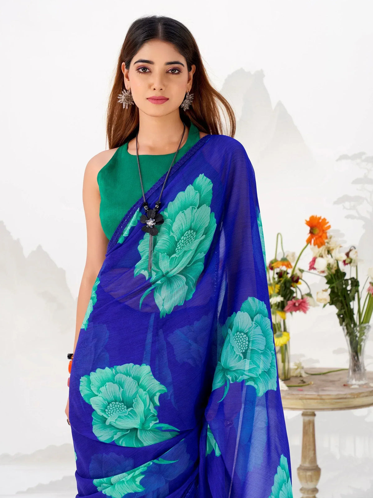 Blue saree with green floral print, paired with green sleeveless blouse, elegant ethnic wear