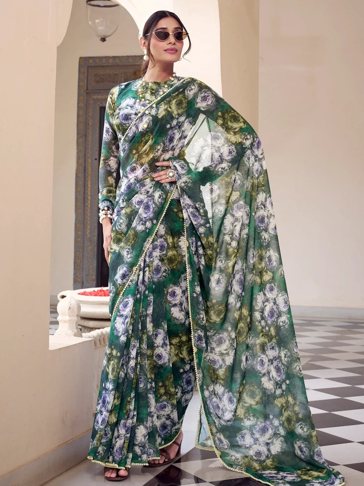 Green floral printed saree with gold trim, styled with sunglasses and pearls for ethnic wear