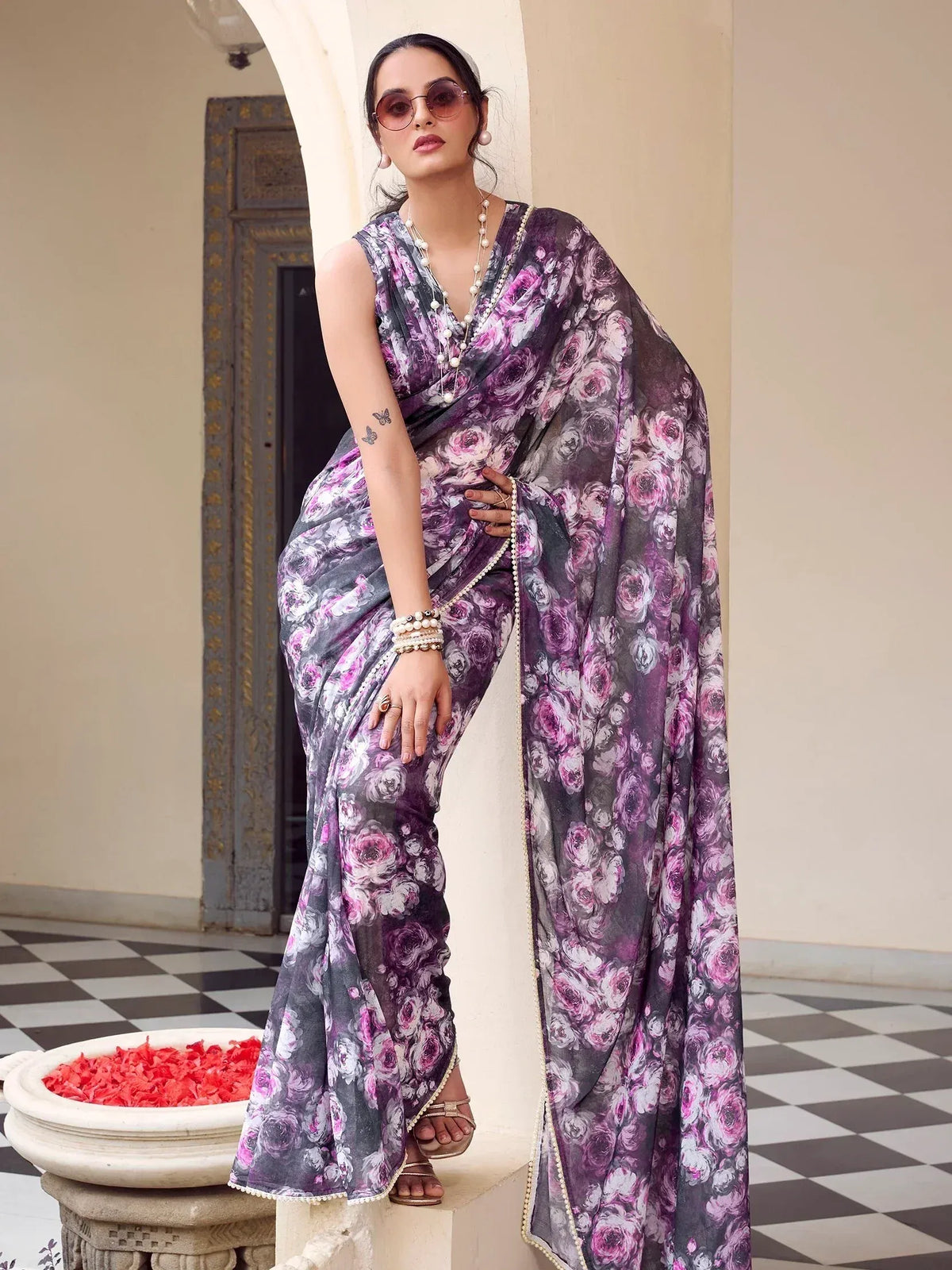 Woman in purple floral printed saree with pearl border, styled for Indian ethnic wear