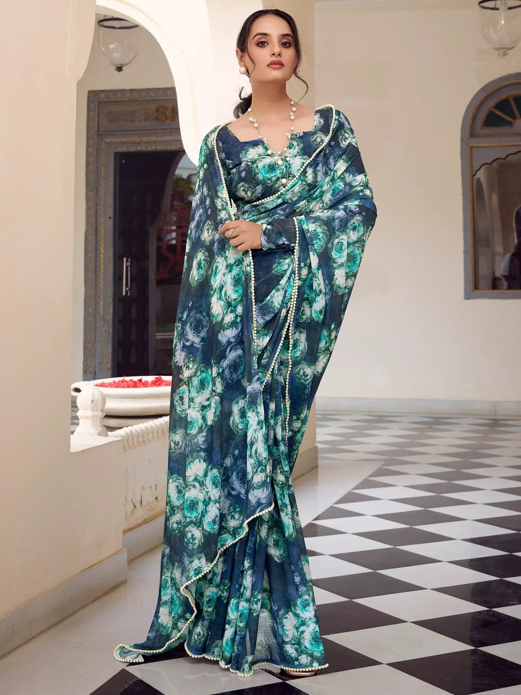 Woman in elegant floral print saree with pearl trim, Indian ethnic wear for festive occasions