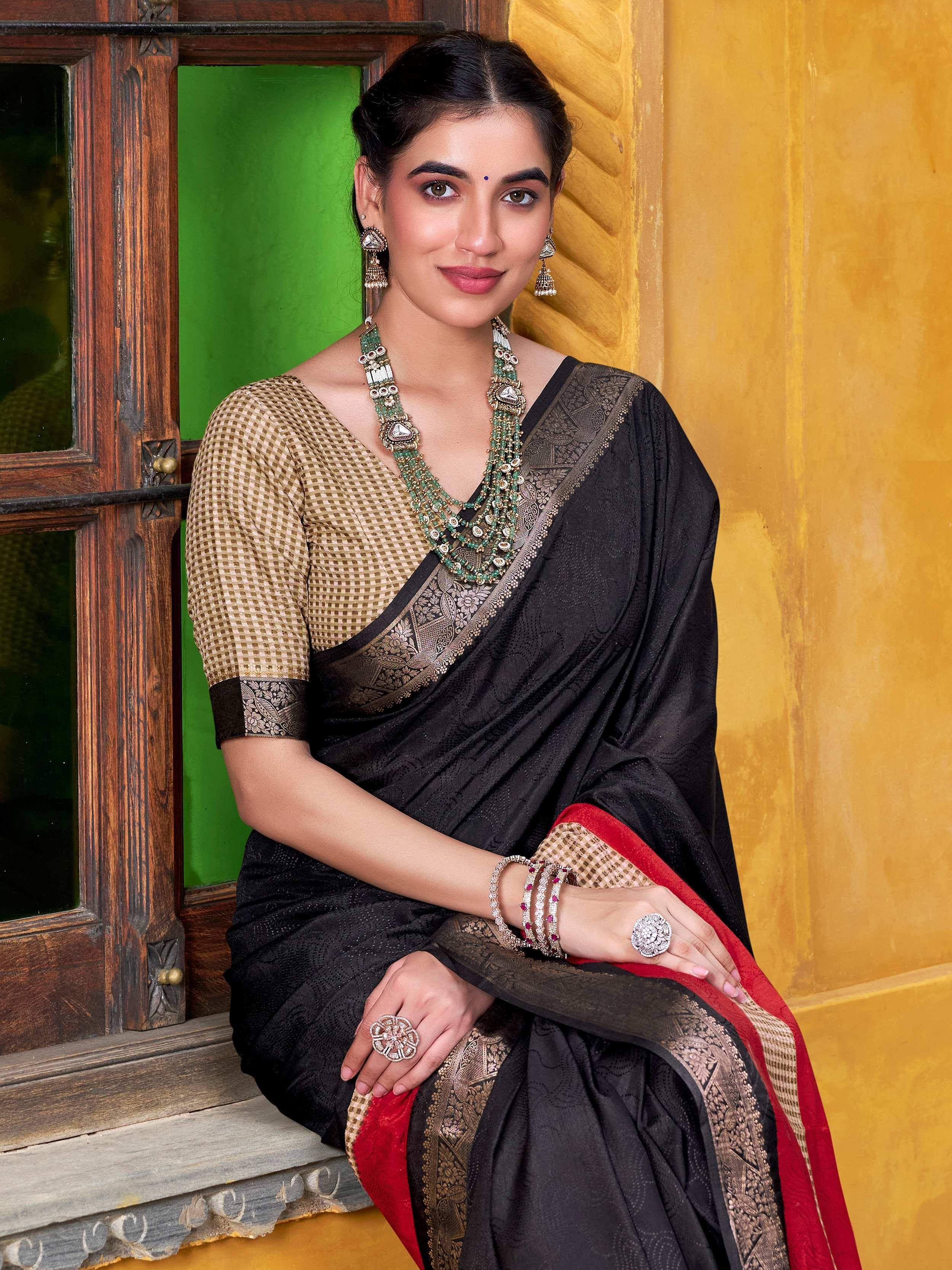 Elegant woman in black designer saree with gold border, paired with traditional jewelry, perfect for ethnic occasions.