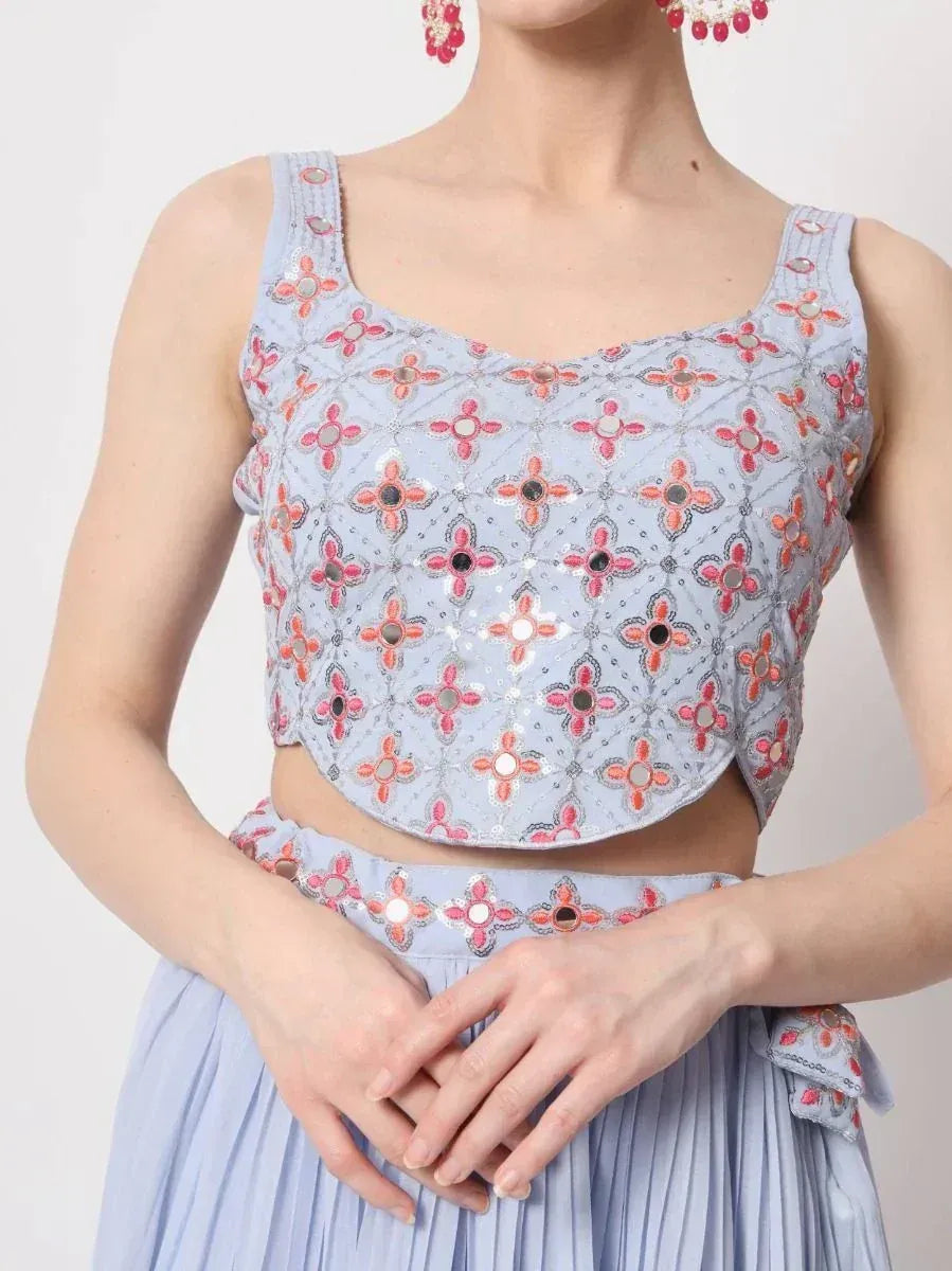 Light blue embroidered crop top with mirror work, paired with matching pleated skirt for ethnic wear