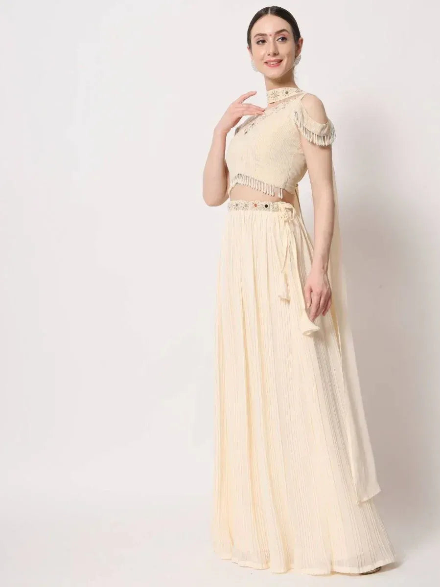 Cream ethnic gown with fringe detailing and pleated skirt, perfect for Indian occasions