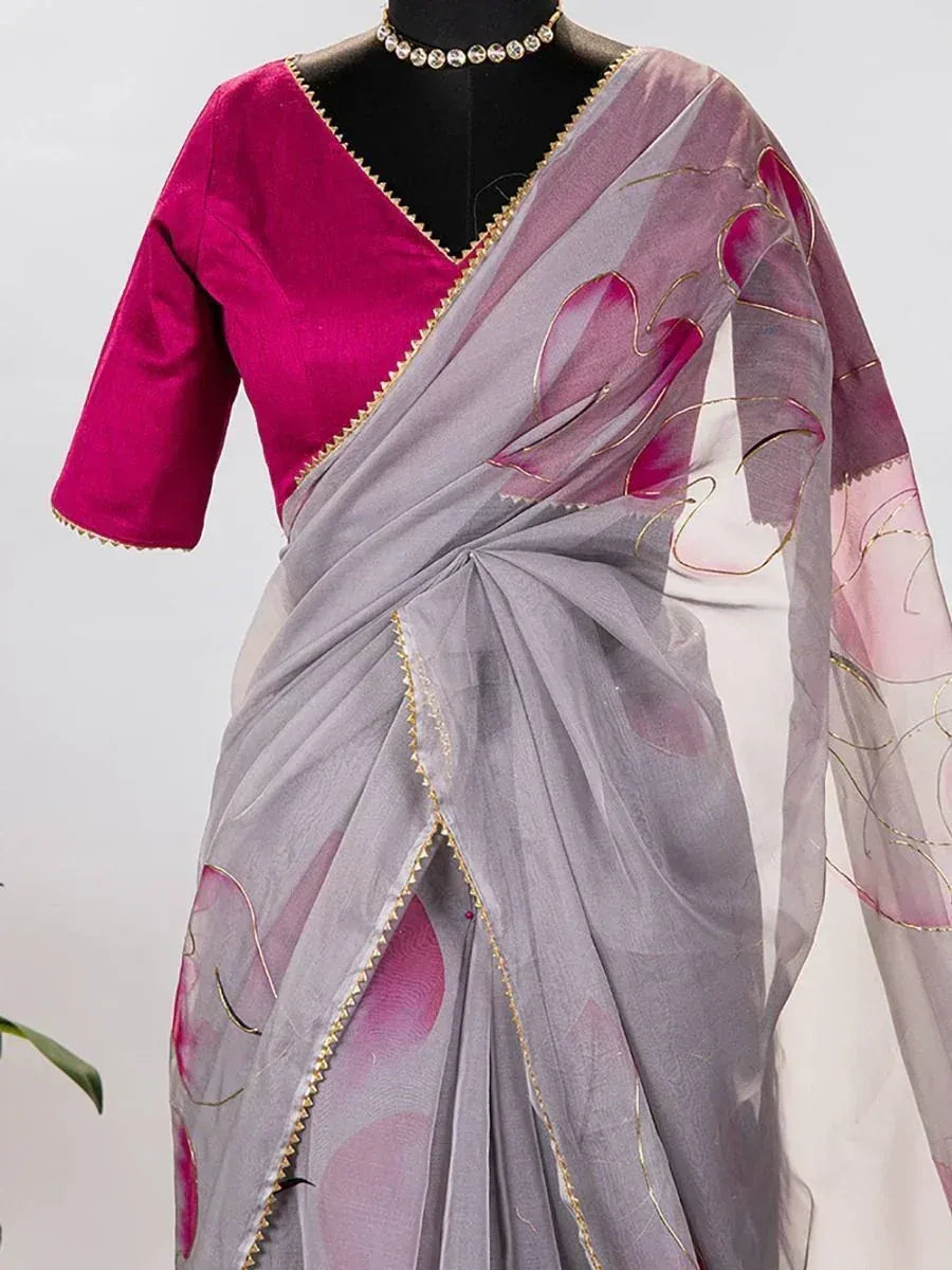 Grey saree with pink floral print and gold trim, paired with magenta blouse for ethnic wear