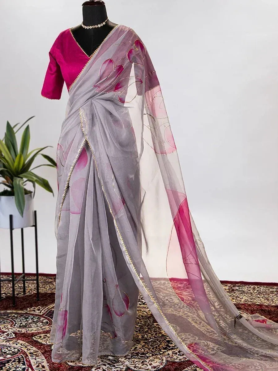 Grey saree with pink floral print and gold border, paired with magenta blouse, displayed on mannequin