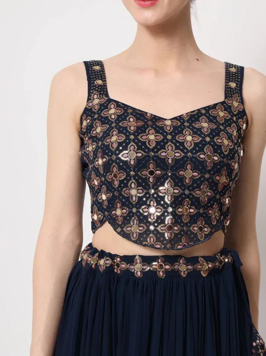 Navy blue embroidered lehenga choli top with floral mirror work and matching skirt, ideal for Indian ethnic wear.