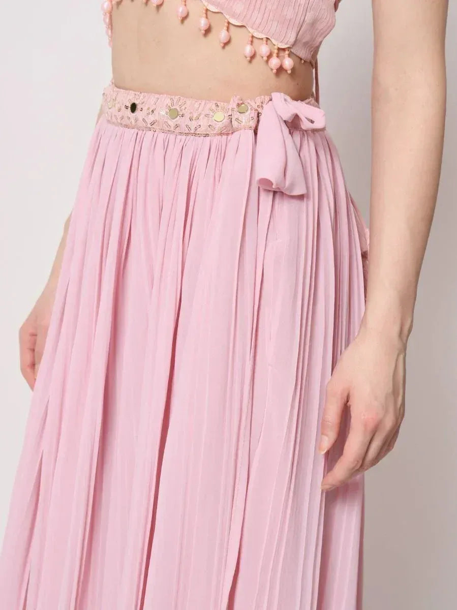 Pink pleated ethnic skirt with embroidered waistband and bow detail, paired with matching top