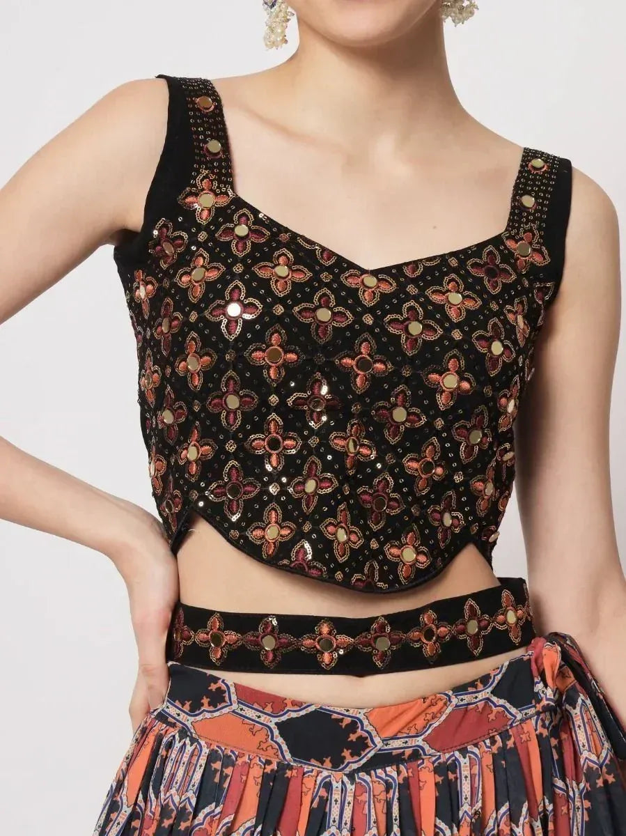 Black embroidered crop top with floral mirror work, paired with printed lehenga skirt for ethnic wear