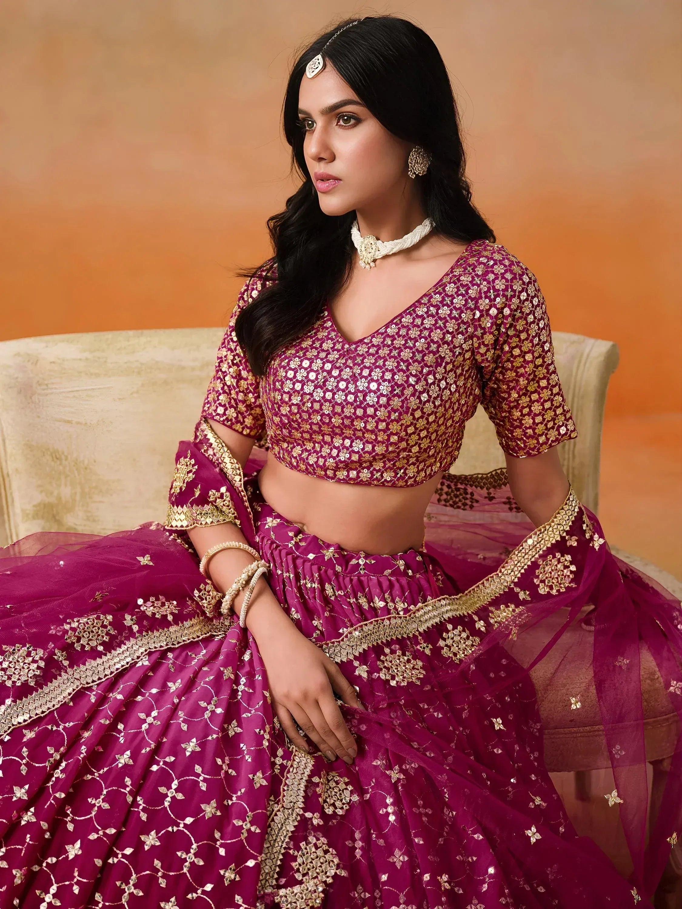 Elegant maroon lehenga choli with gold embroidery, perfect for Indian weddings and festive occasions.