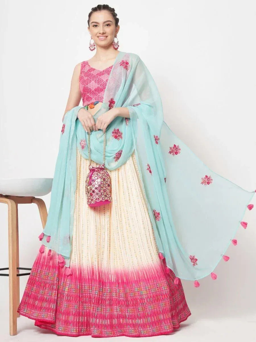 Pink and mint lehenga choli with floral embroidery, tassels, and matching potli bag for Indian ethnic wear