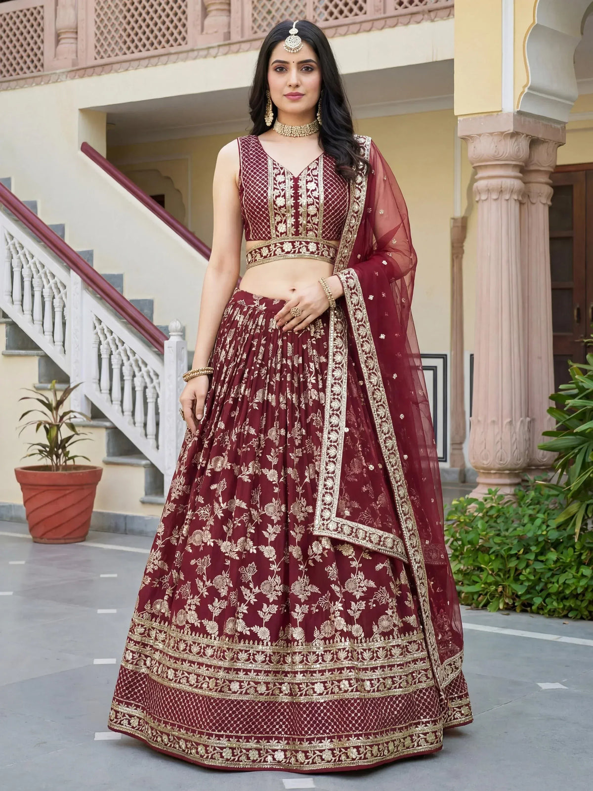 Maroon embroidered lehenga choli with gold floral work, perfect for Indian weddings and festive occasions.