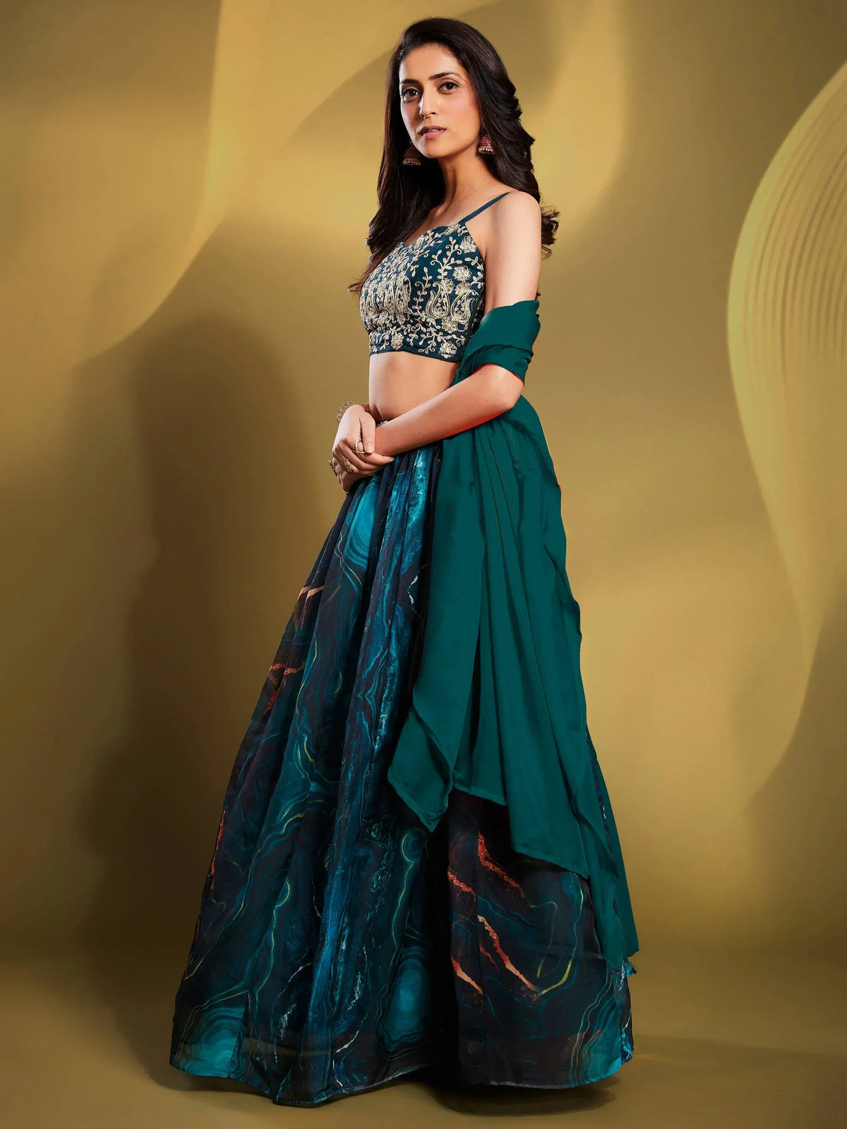 Elegant teal lehenga choli with gold embroidery and marbled skirt design