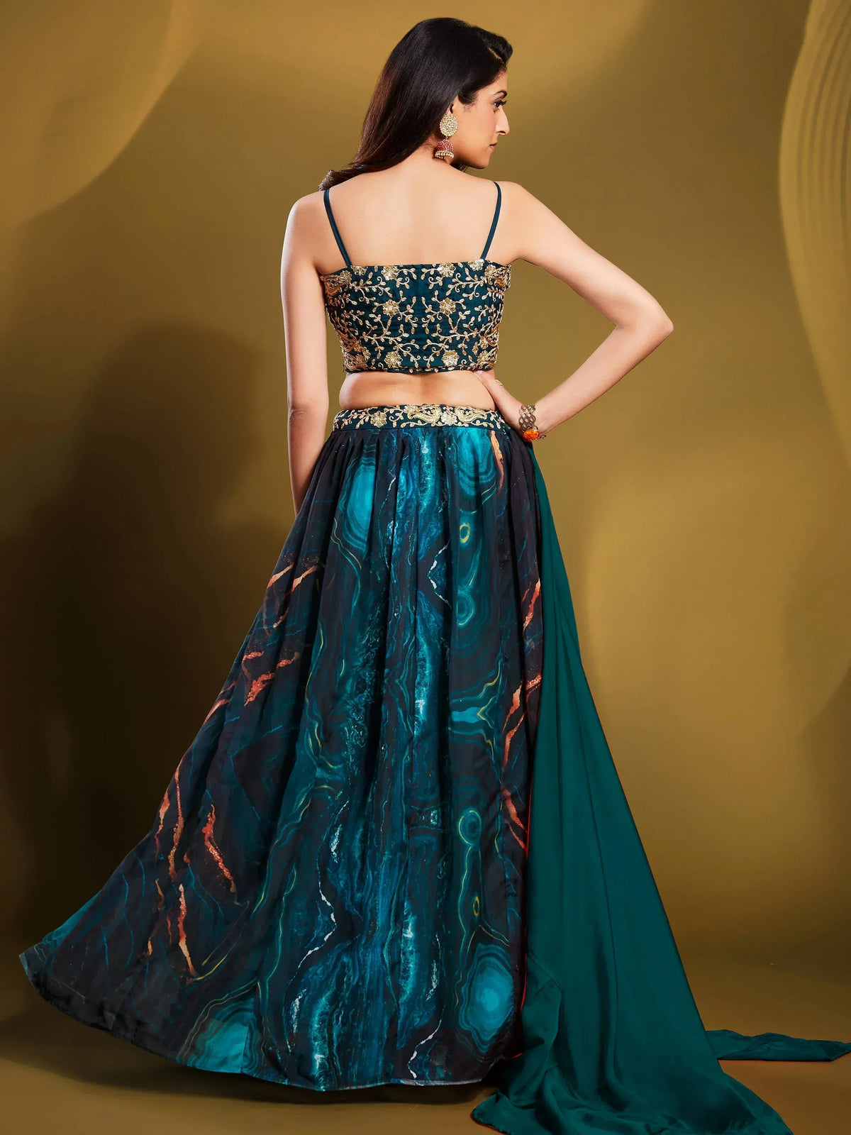 Elegant teal lehenga choli with gold embroidery and marbled skirt design