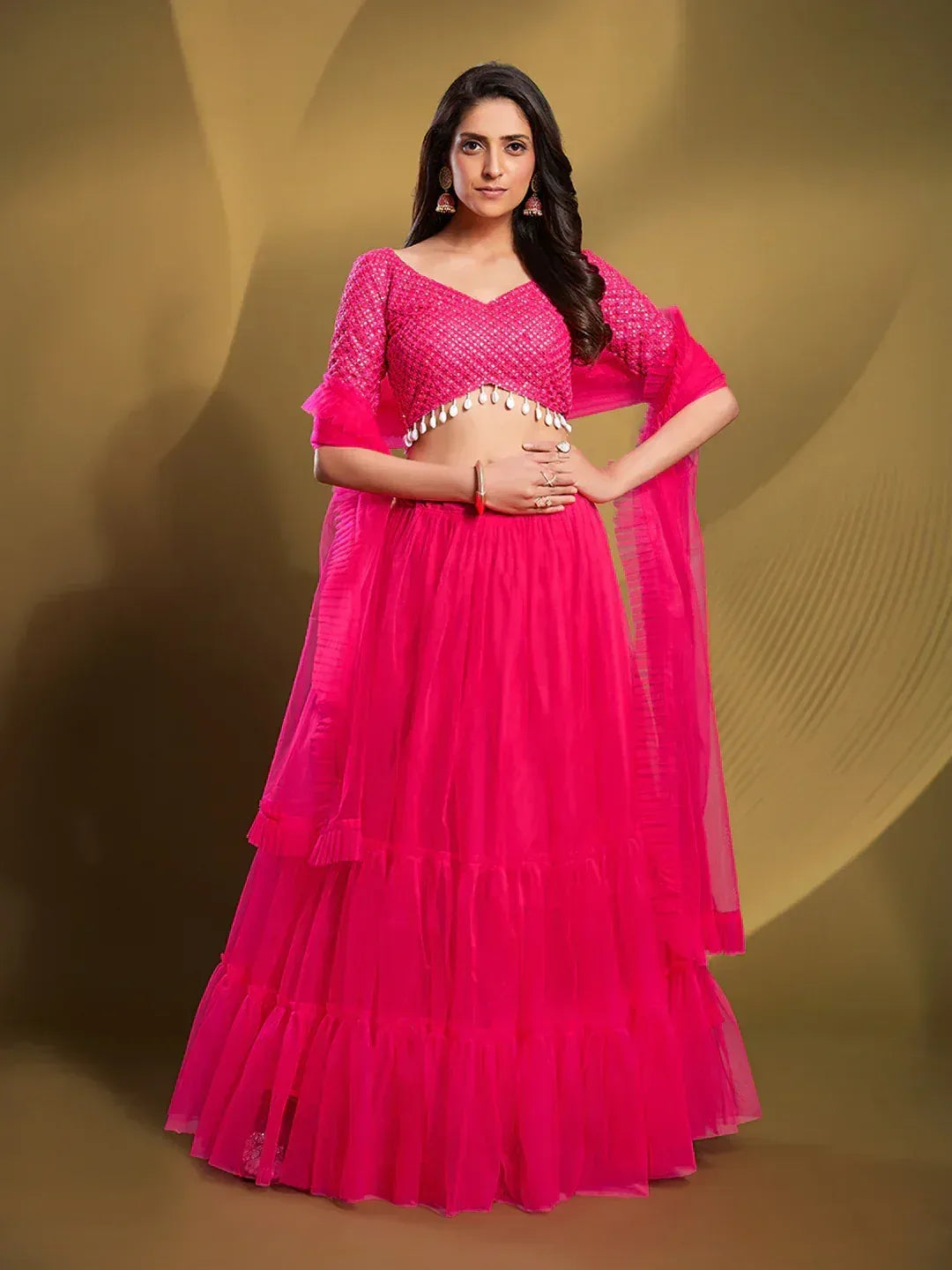 Vibrant pink designer lehenga choli with layered skirt and embellished blouse