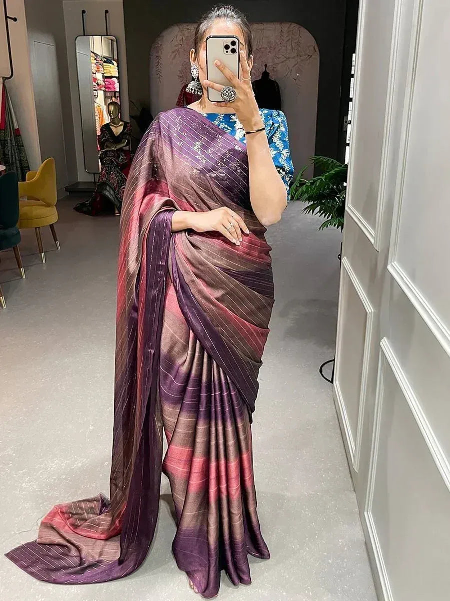 Woman wearing elegant purple and pink striped saree with blue blouse, perfect for ethnic occasions