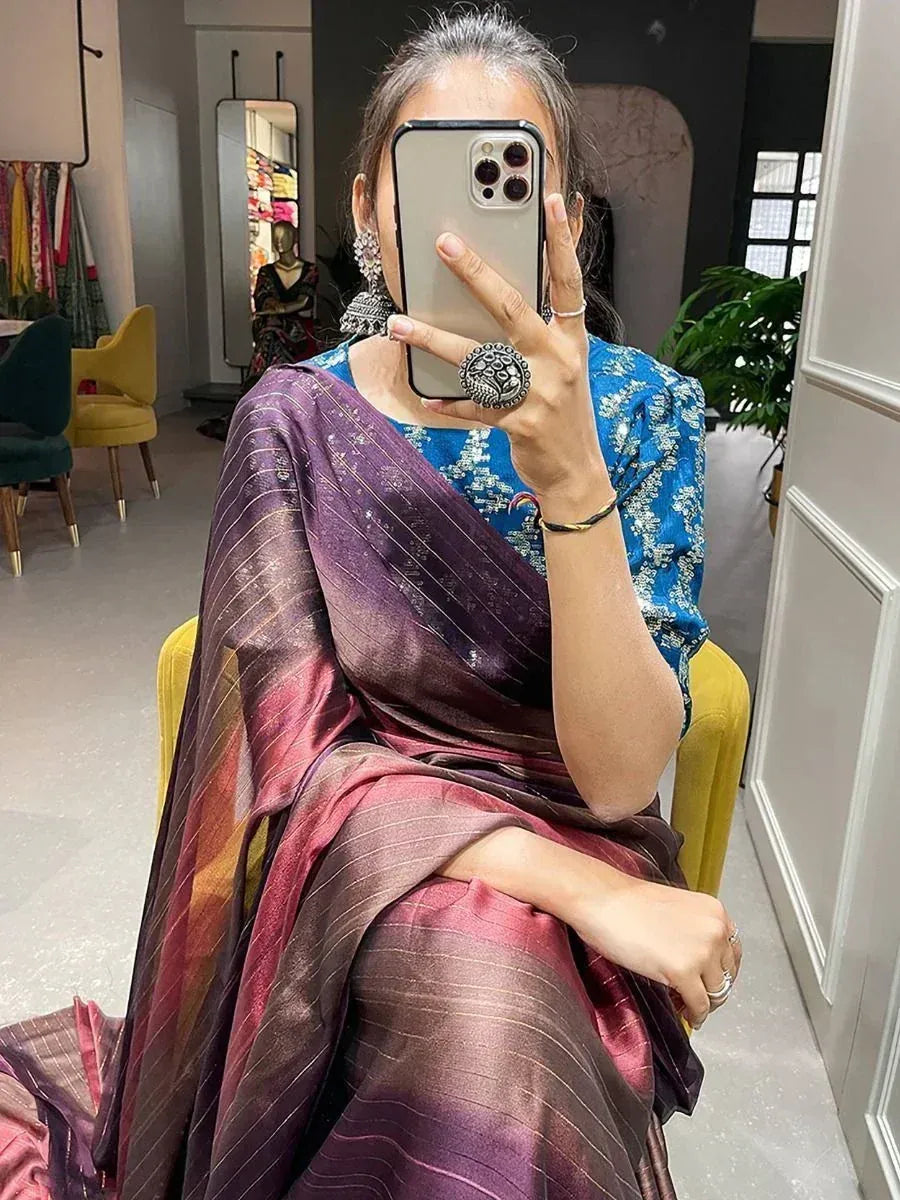Woman in purple and blue ethnic saree with intricate patterns, taking mirror selfie in boutique