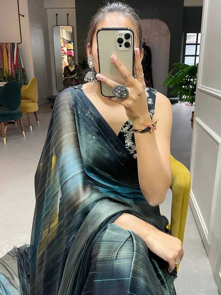 Woman in elegant dark green striped saree with embellished blouse, taking mirror selfie in boutique