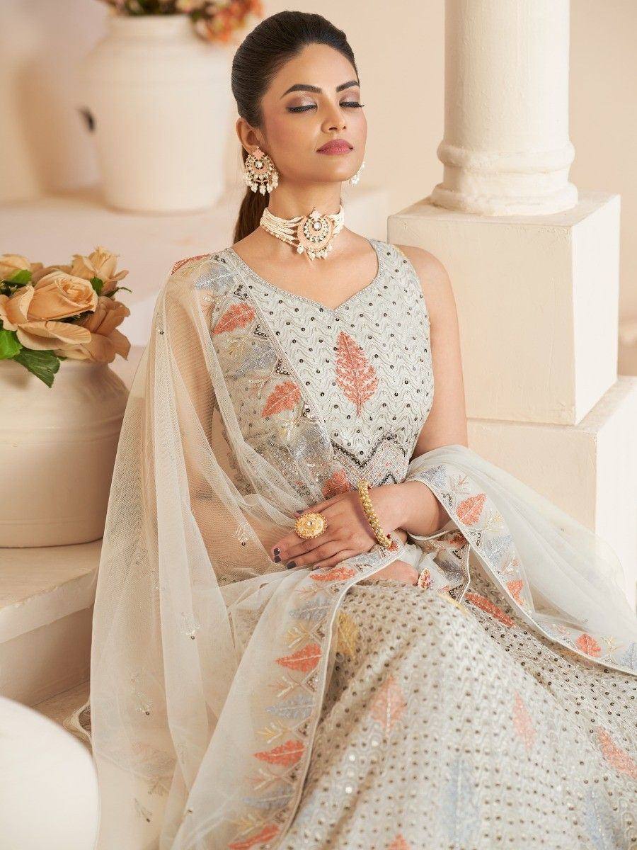 Elegant white embroidered lehenga choli with peach leaf motifs, perfect for Indian ethnic wear occasions.