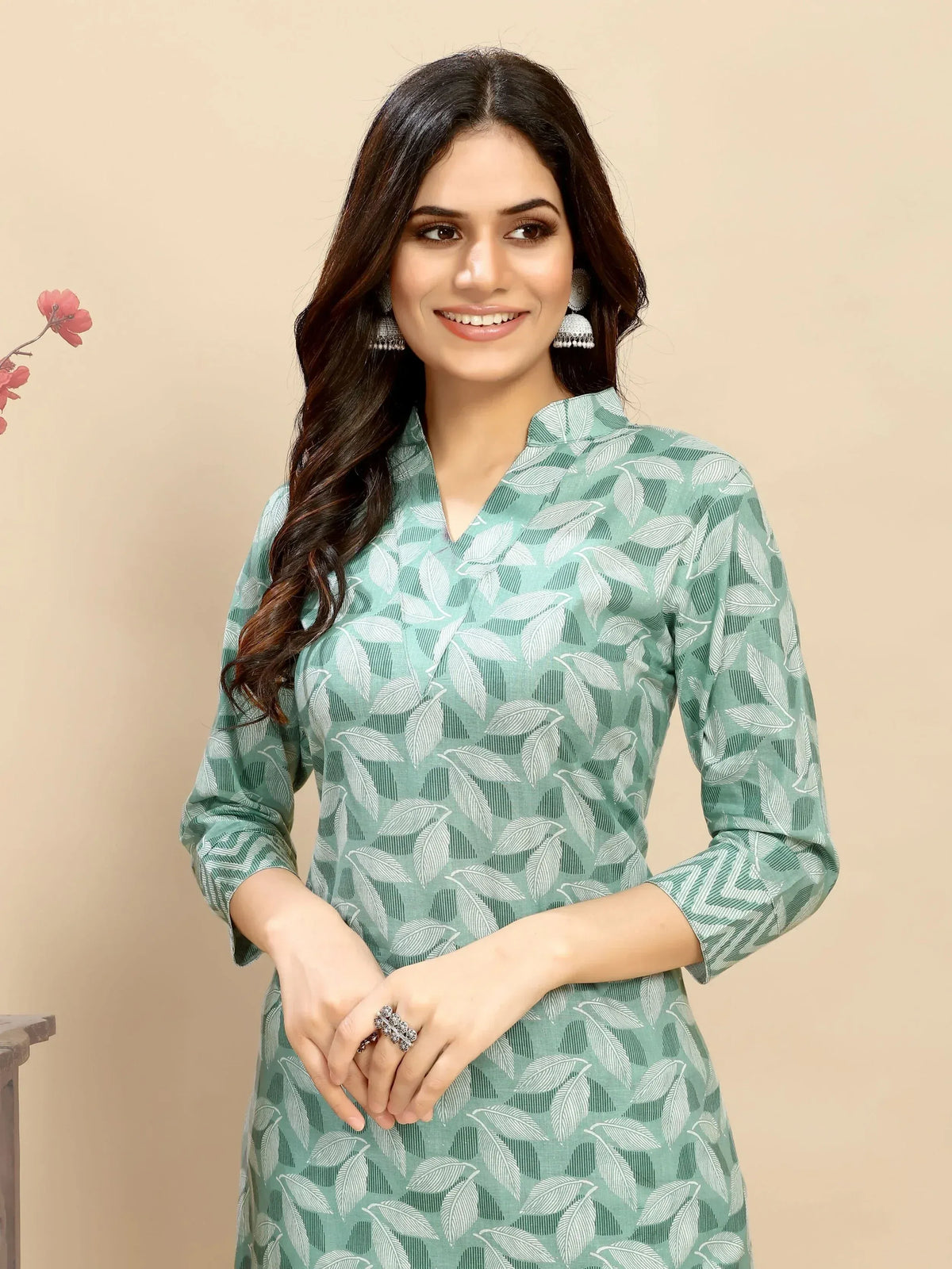 Woman in mint green leaf print ethnic kurti with silver jhumka earrings, perfect for Indian wear.
