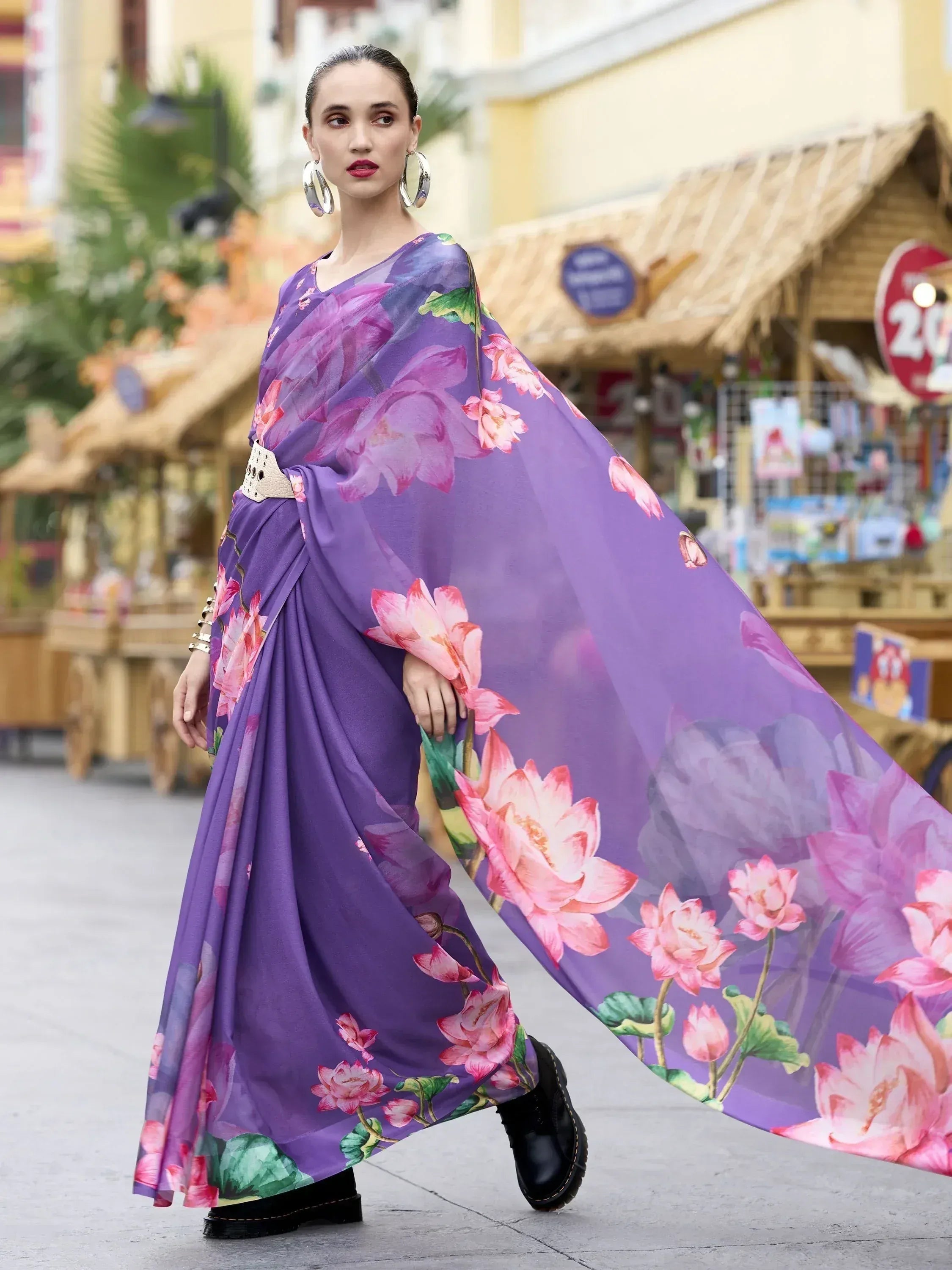 Purple floral print saree with pink lotus design, styled with belt and boots for modern ethnic look